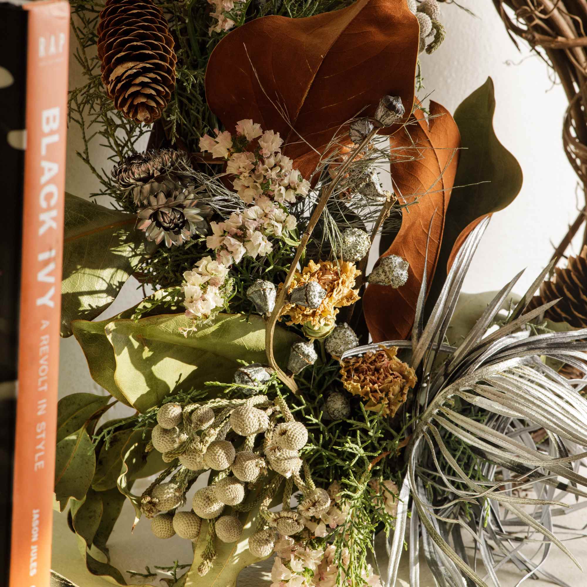 Dried floral wreath with pinecones, seed pods, and muted leaves