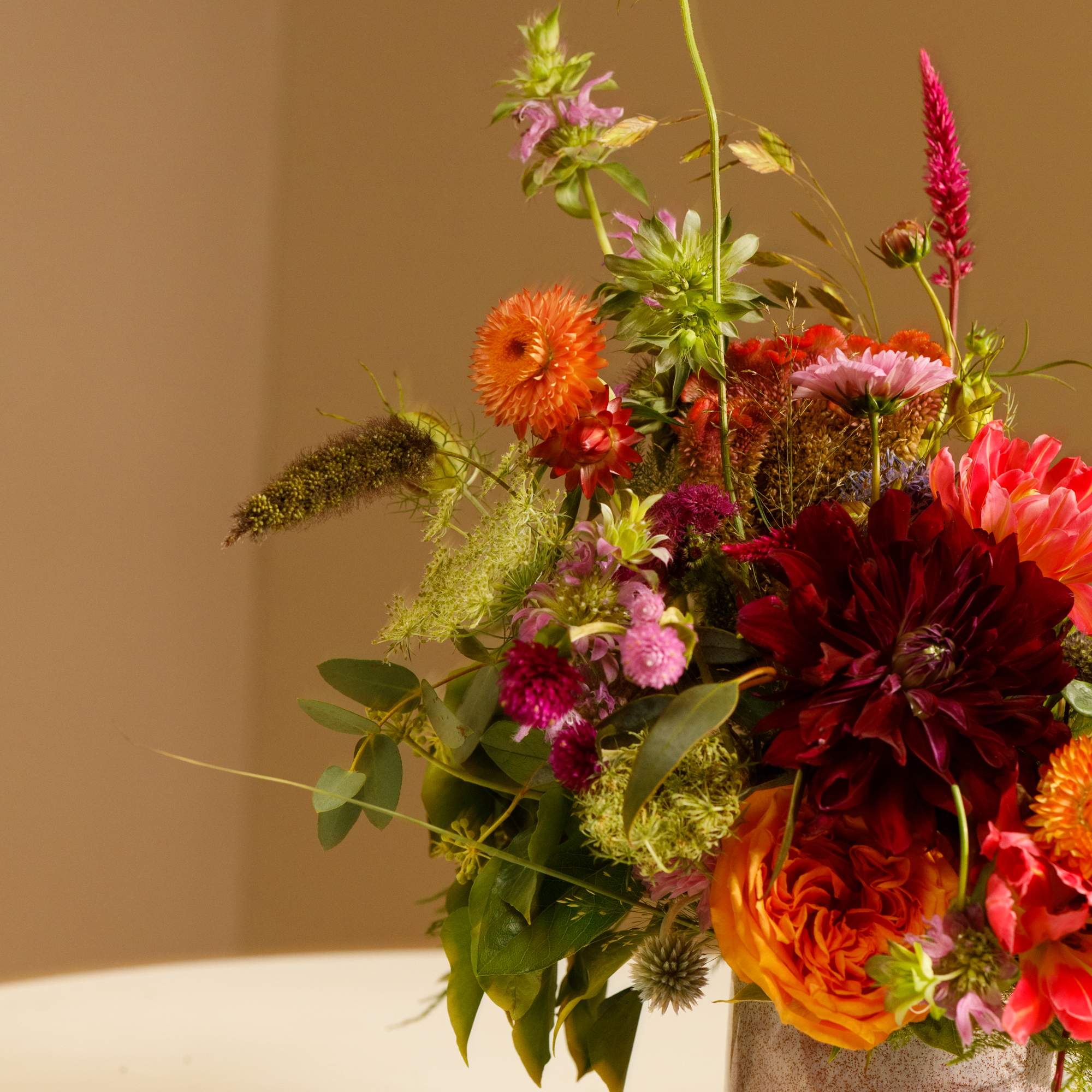 Colorful mixed bouquet in a speckled ceramic vase