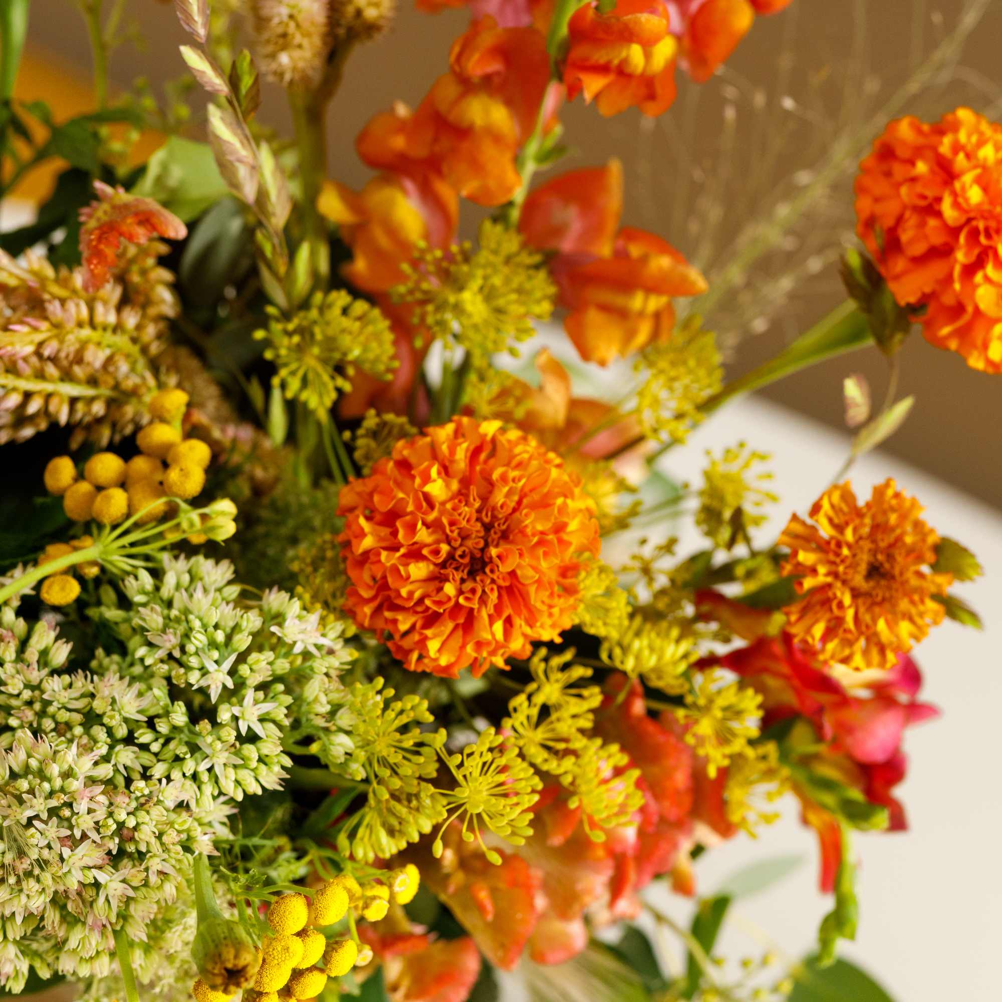 Orange and yellow mixed bouquet with round blooms and tall spikes