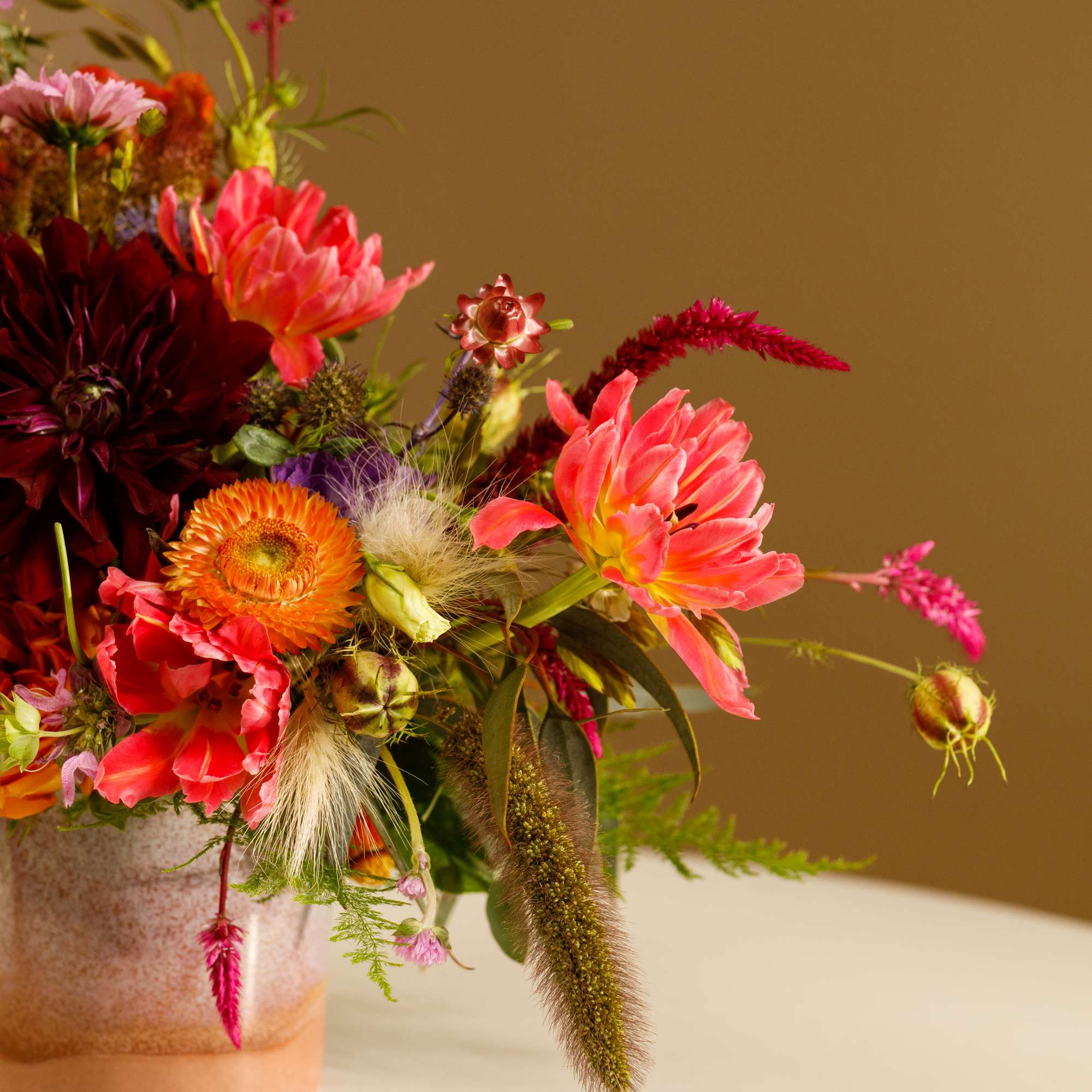 Colorful mixed flower arrangement in a textured vase