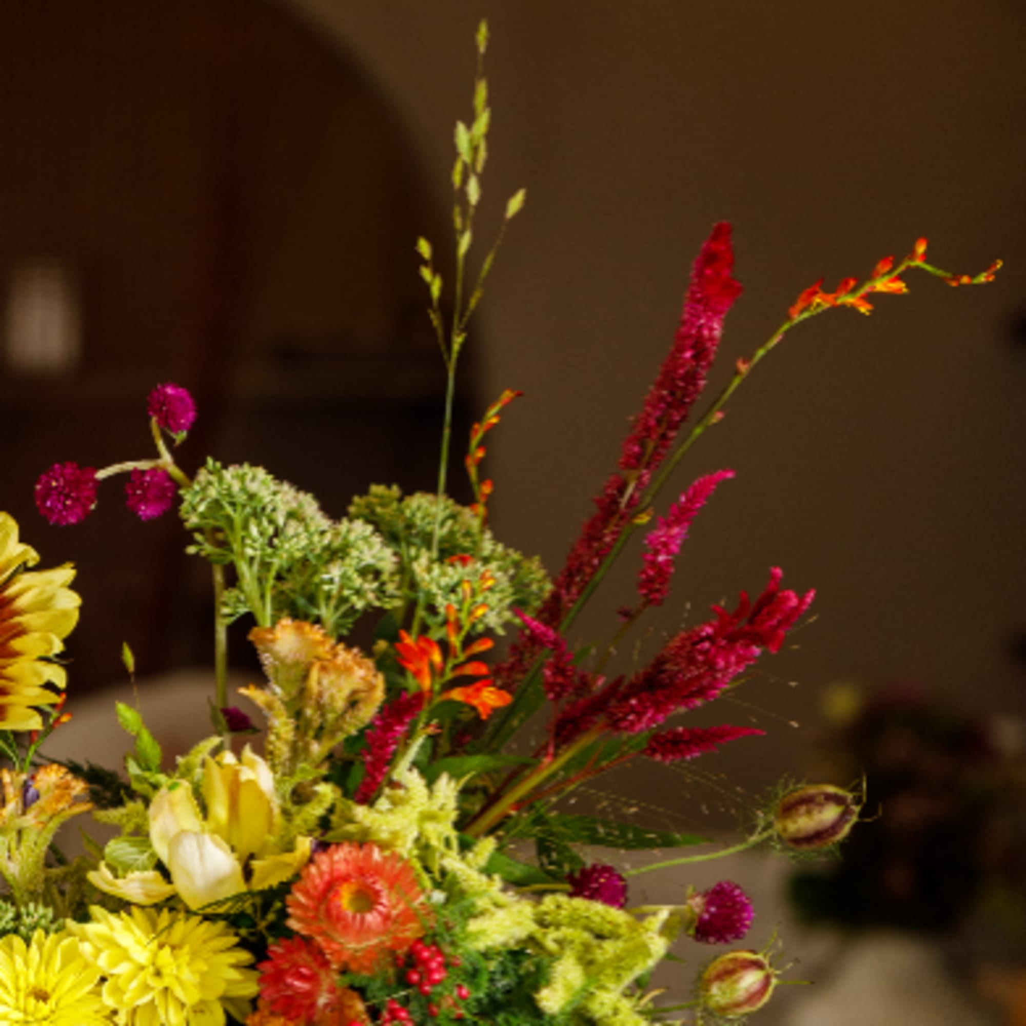 Colorful mixed flower arrangement with tall magenta spikes and yellow blooms
