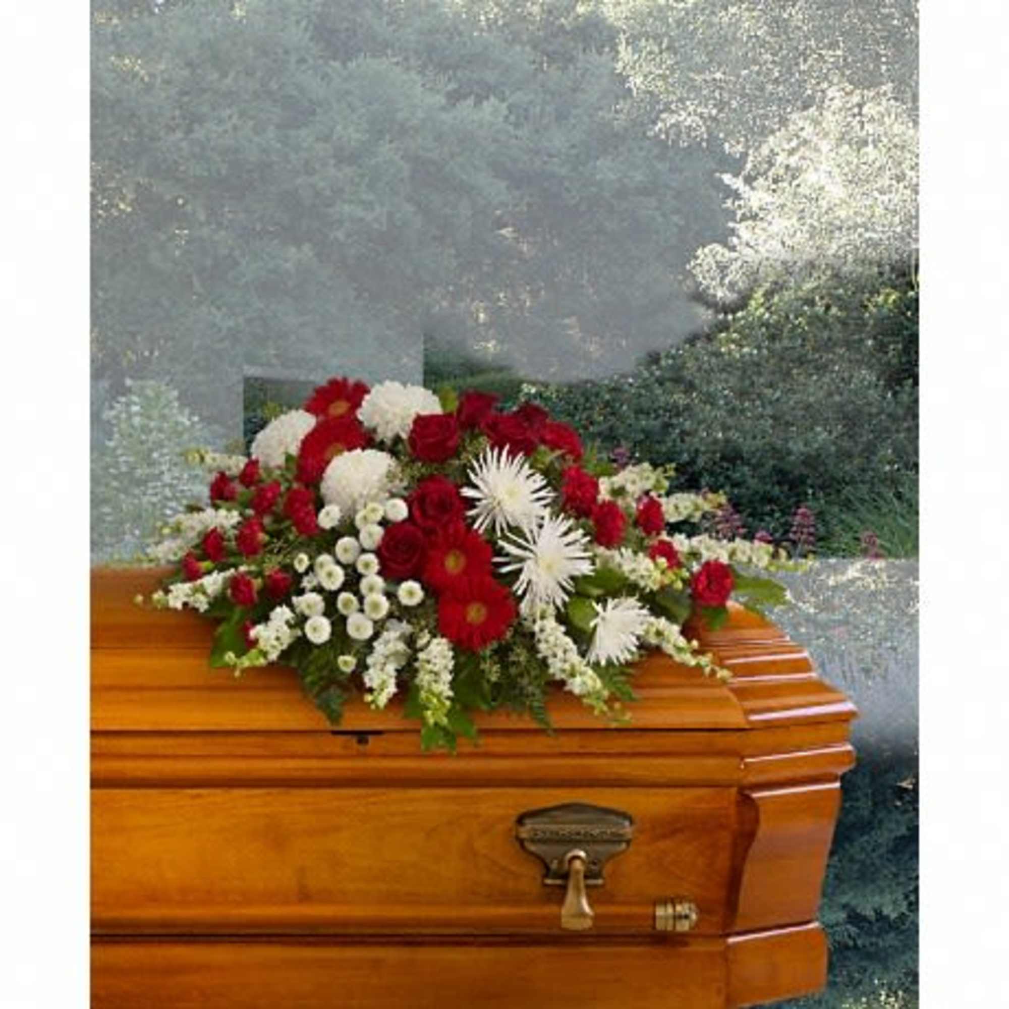 Red and white funeral spray on a wooden casket