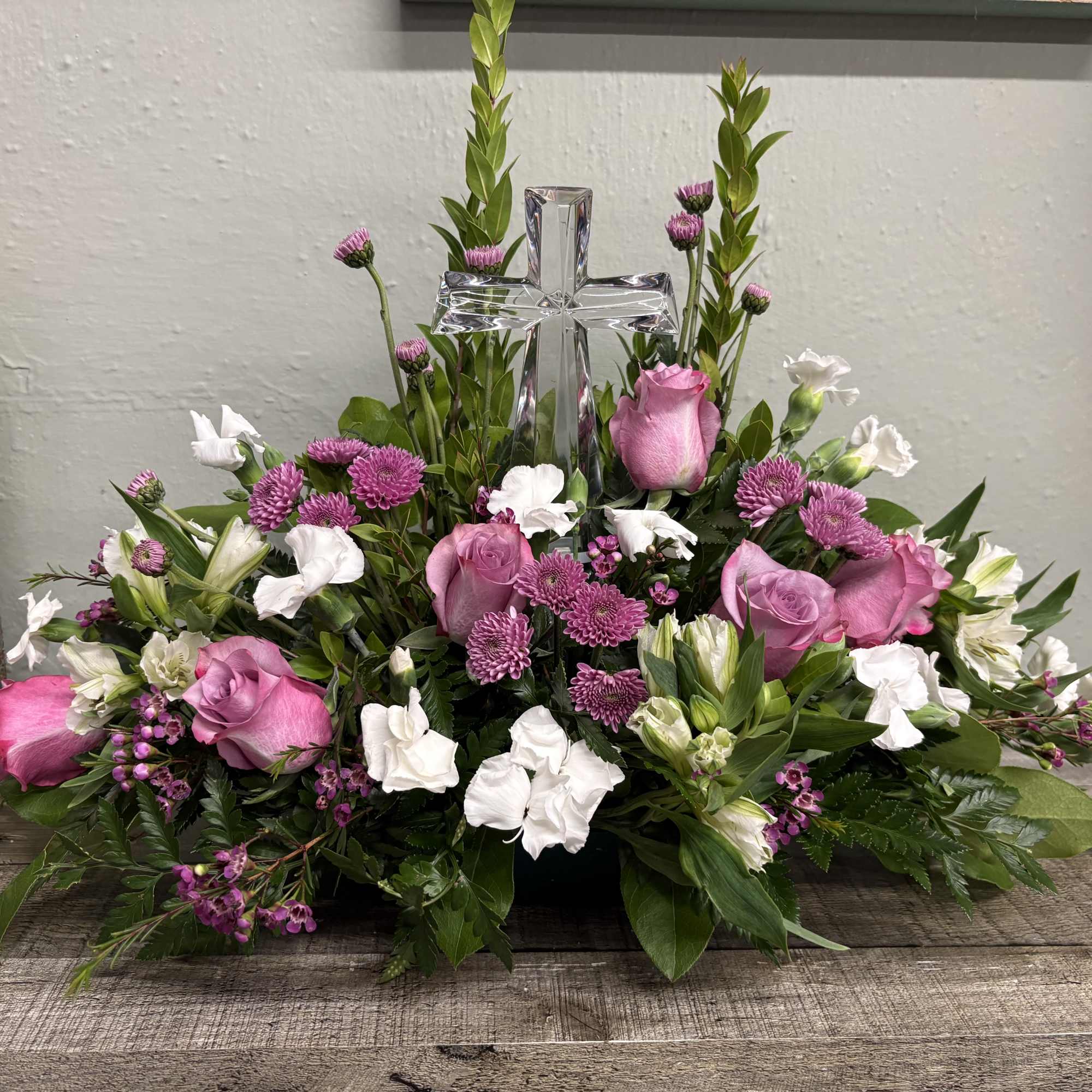 Pink and white floral arrangement with a clear cross centerpiece