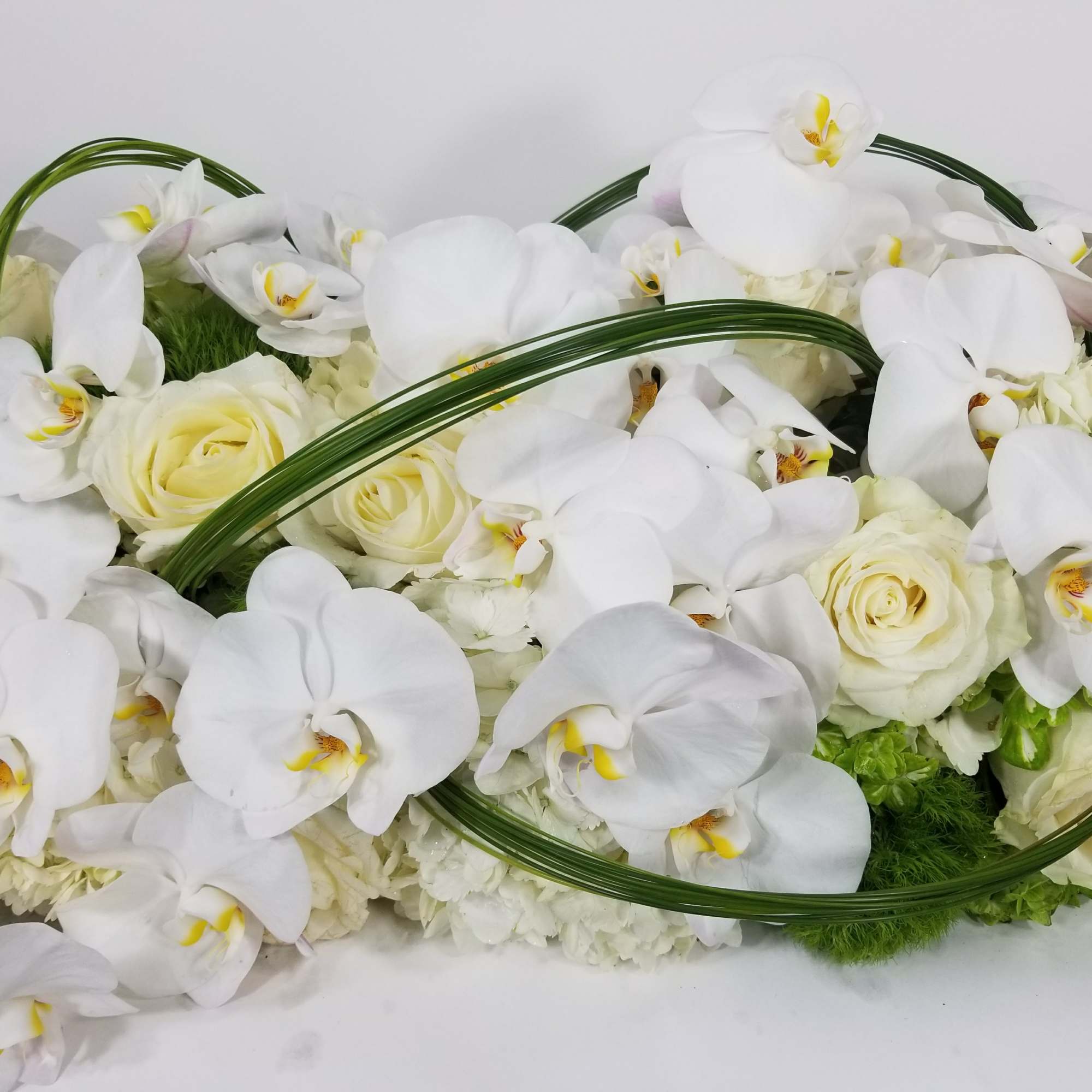 An arrangement with orchids, roses, hydrangeas, and greenery, photo 2 of 2