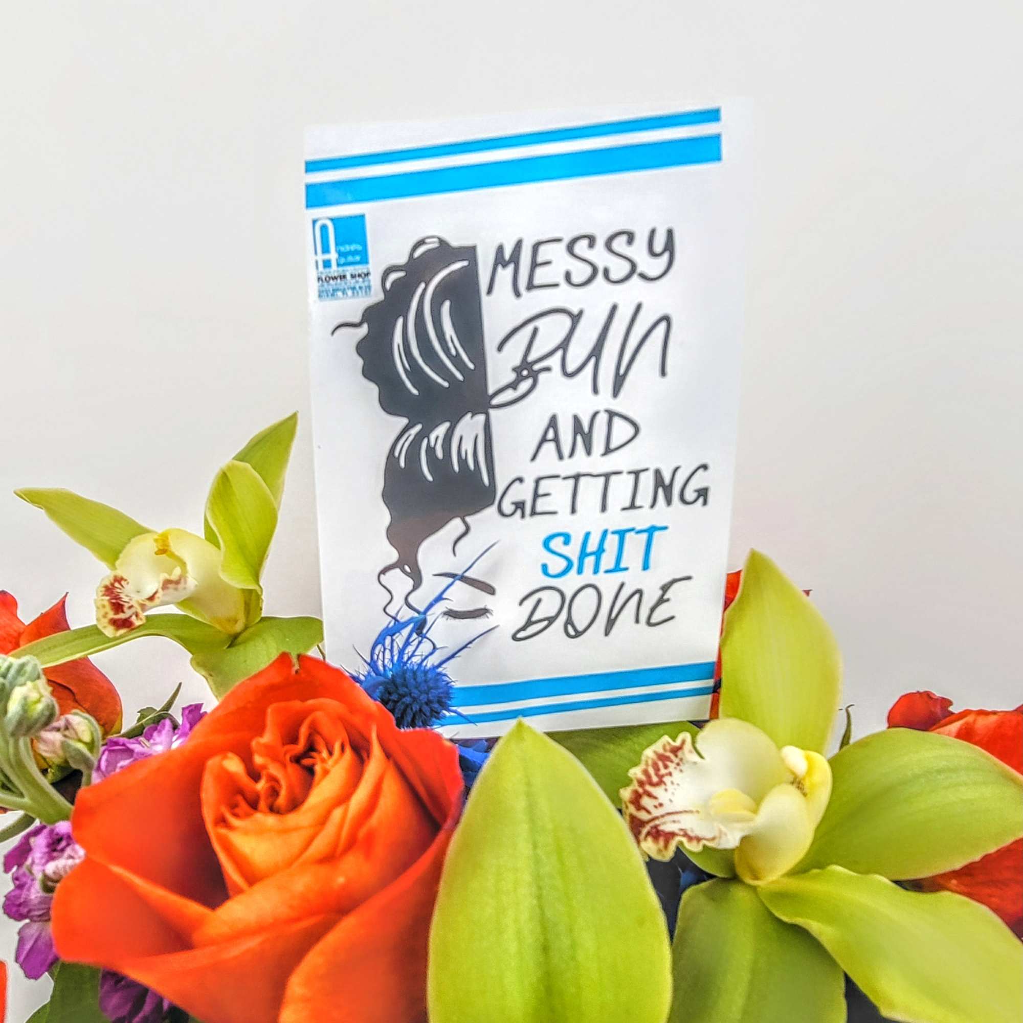Bouquet of orange roses and green orchids with a humorous card