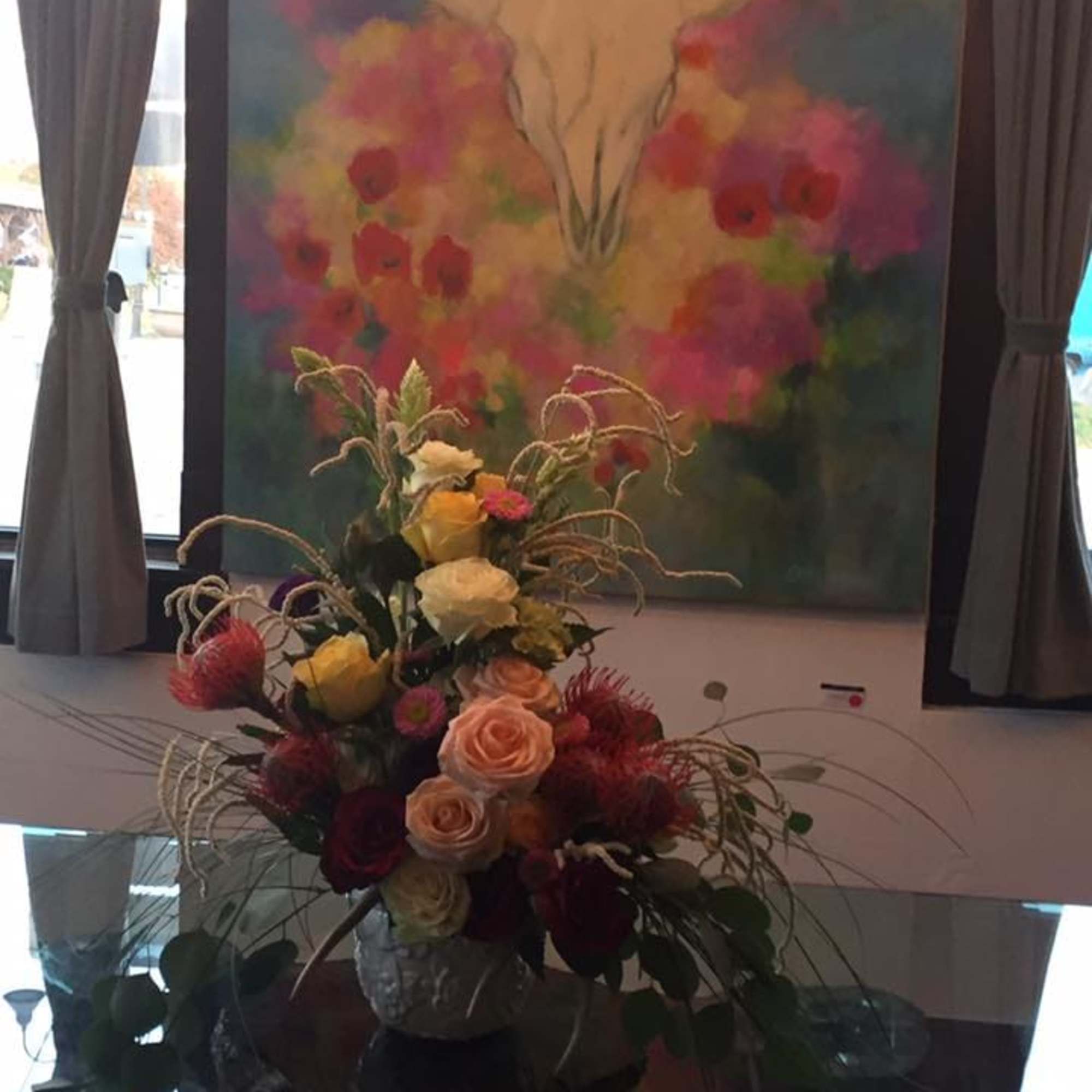 Tall floral arrangement with roses and spiky accent flowers in a vase