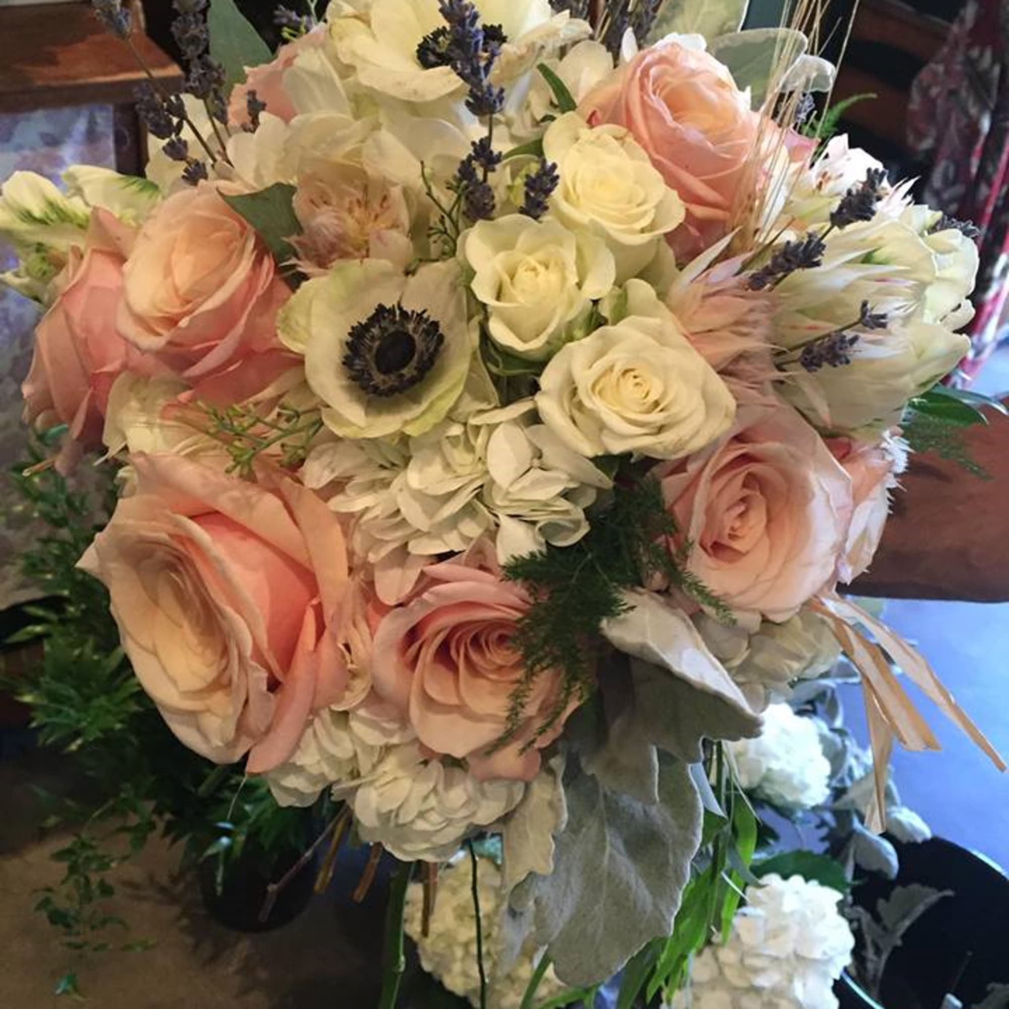 Bouquet of blush roses, white hydrangeas, and pale blooms with lavender accents