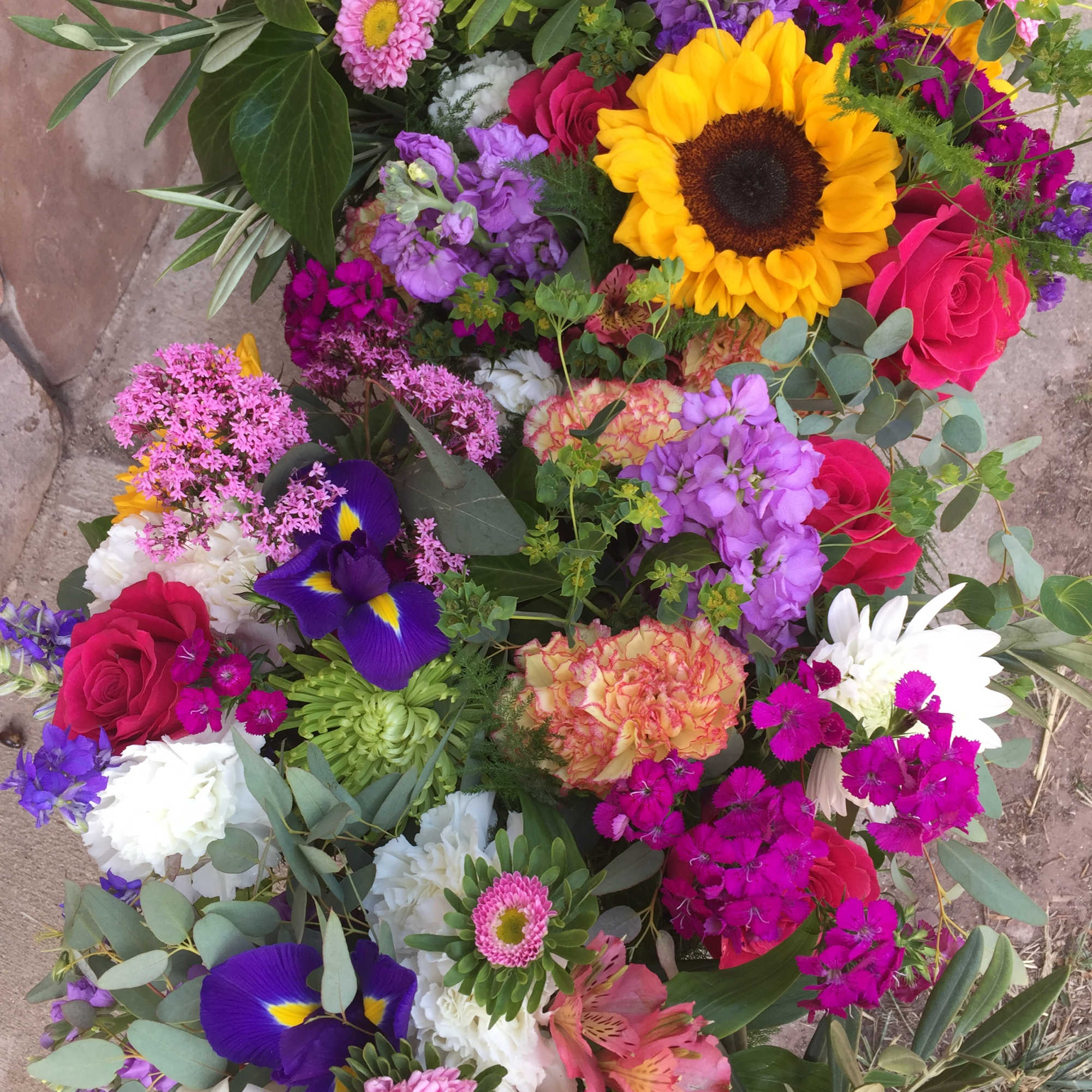 Colorful mixed bouquet with sunflowers, roses, and purple blooms