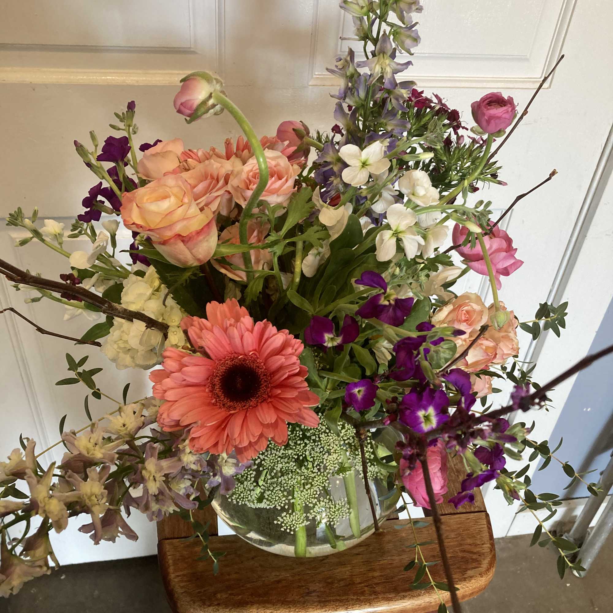 Mixed bouquet in a glass vase with pink, peach, purple, and white flowers