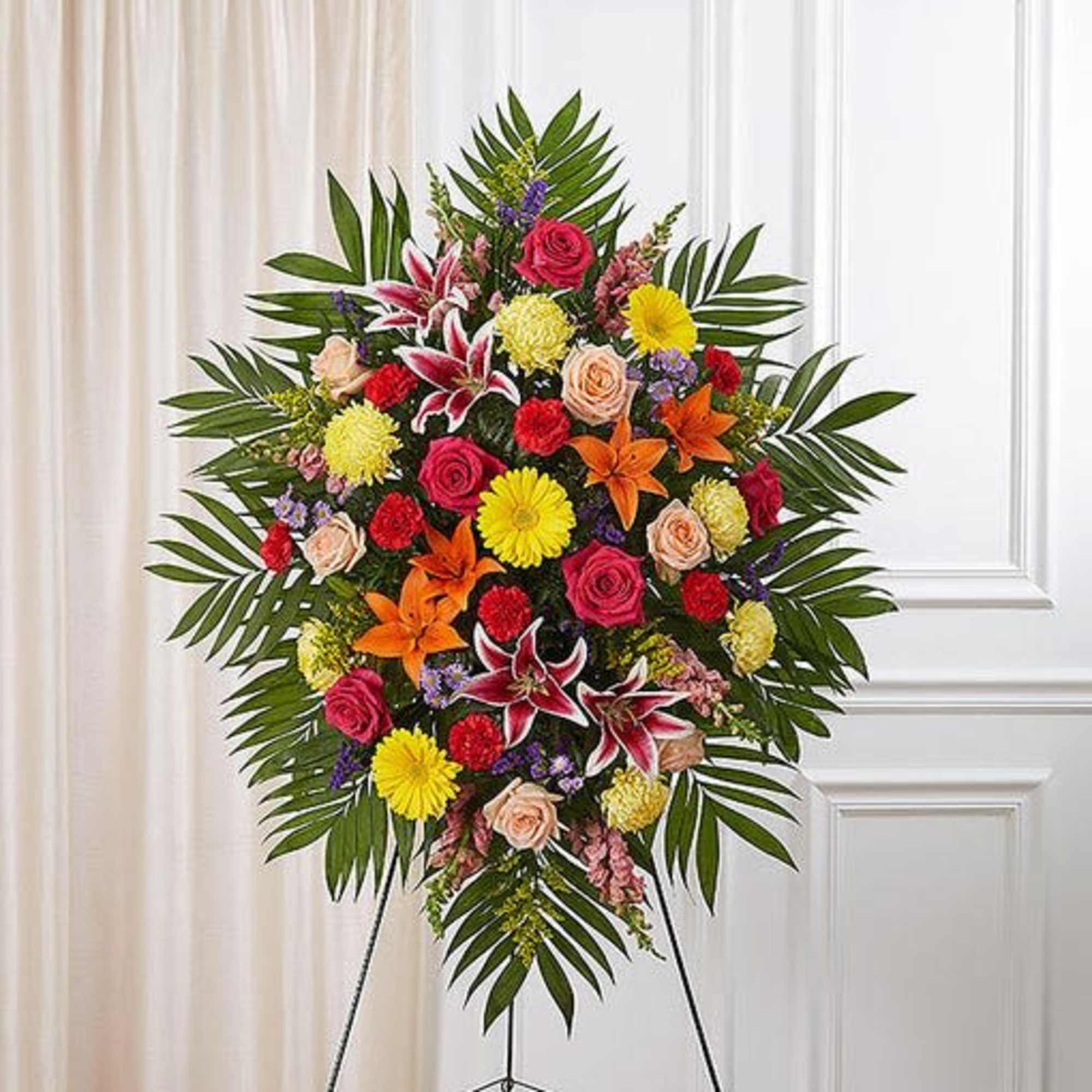 Standing floral spray with roses, lilies, and daisies on an easel