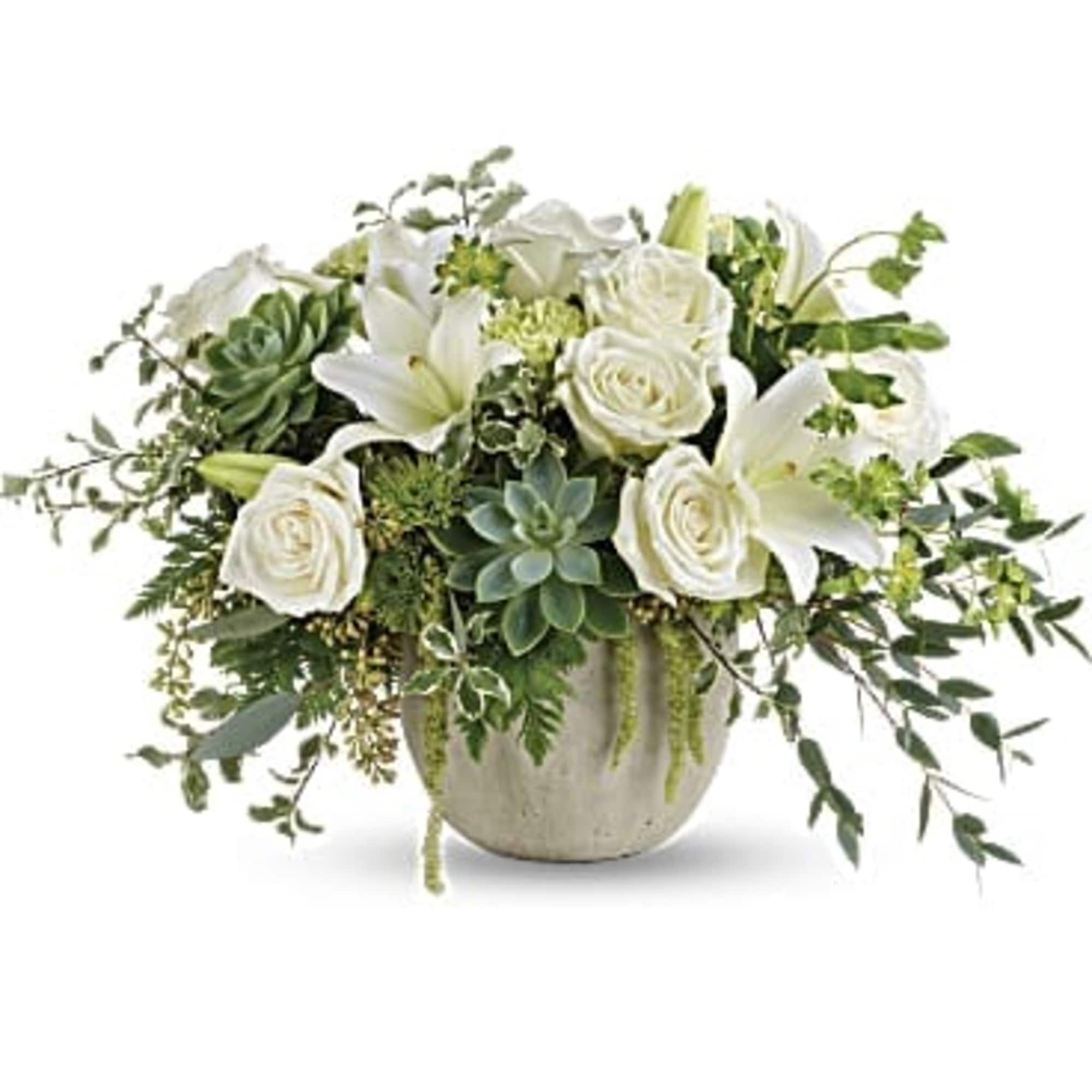 White roses and lilies arranged in a round ceramic vase with succulents