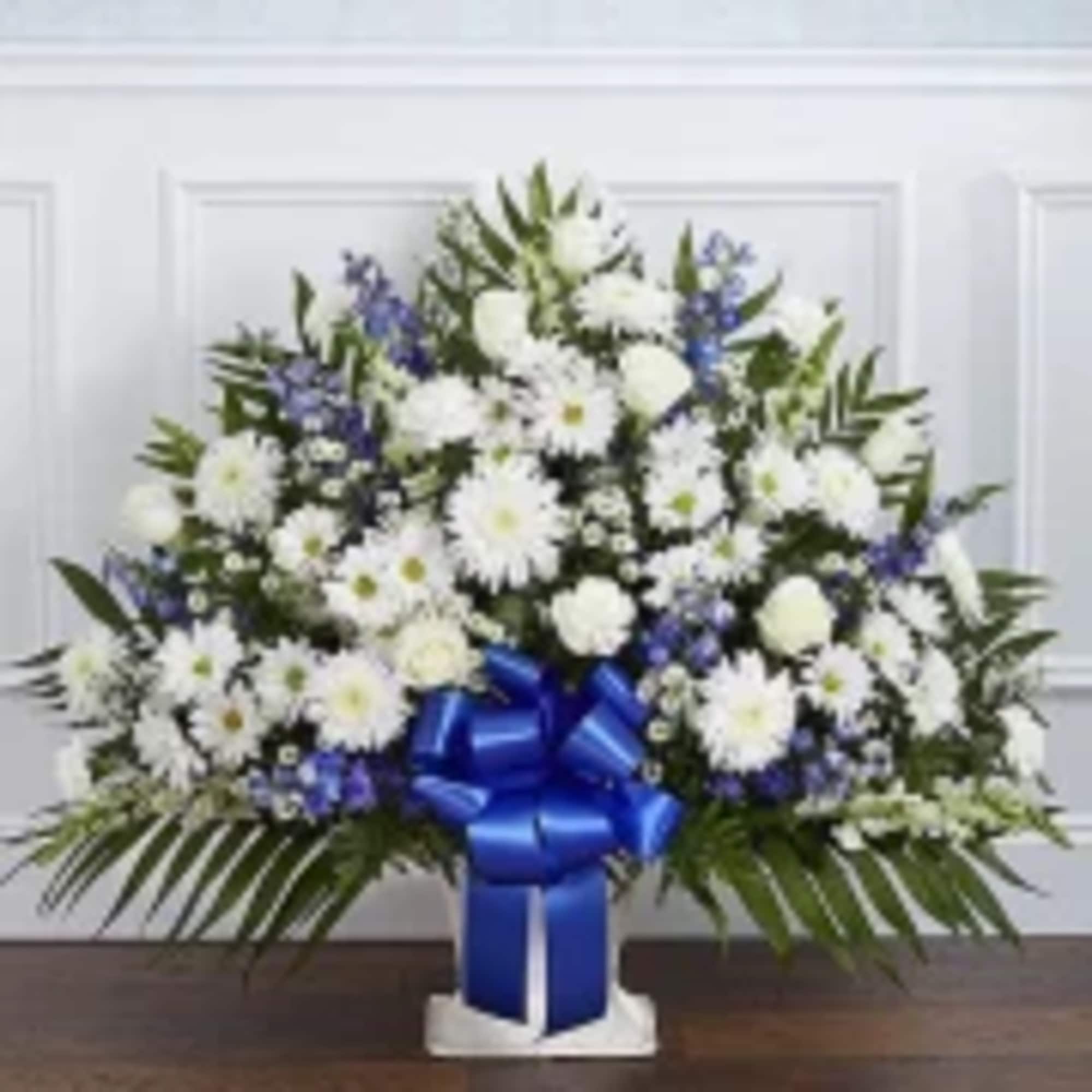 White and blue floral arrangement with a large blue ribbon
