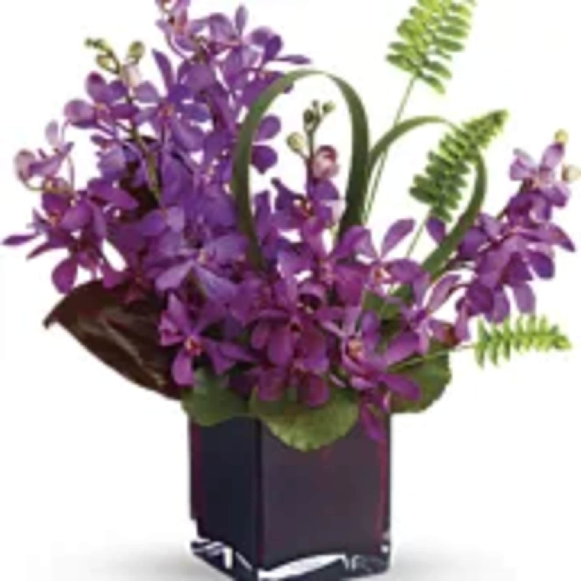Purple orchid arrangement in a dark square vase