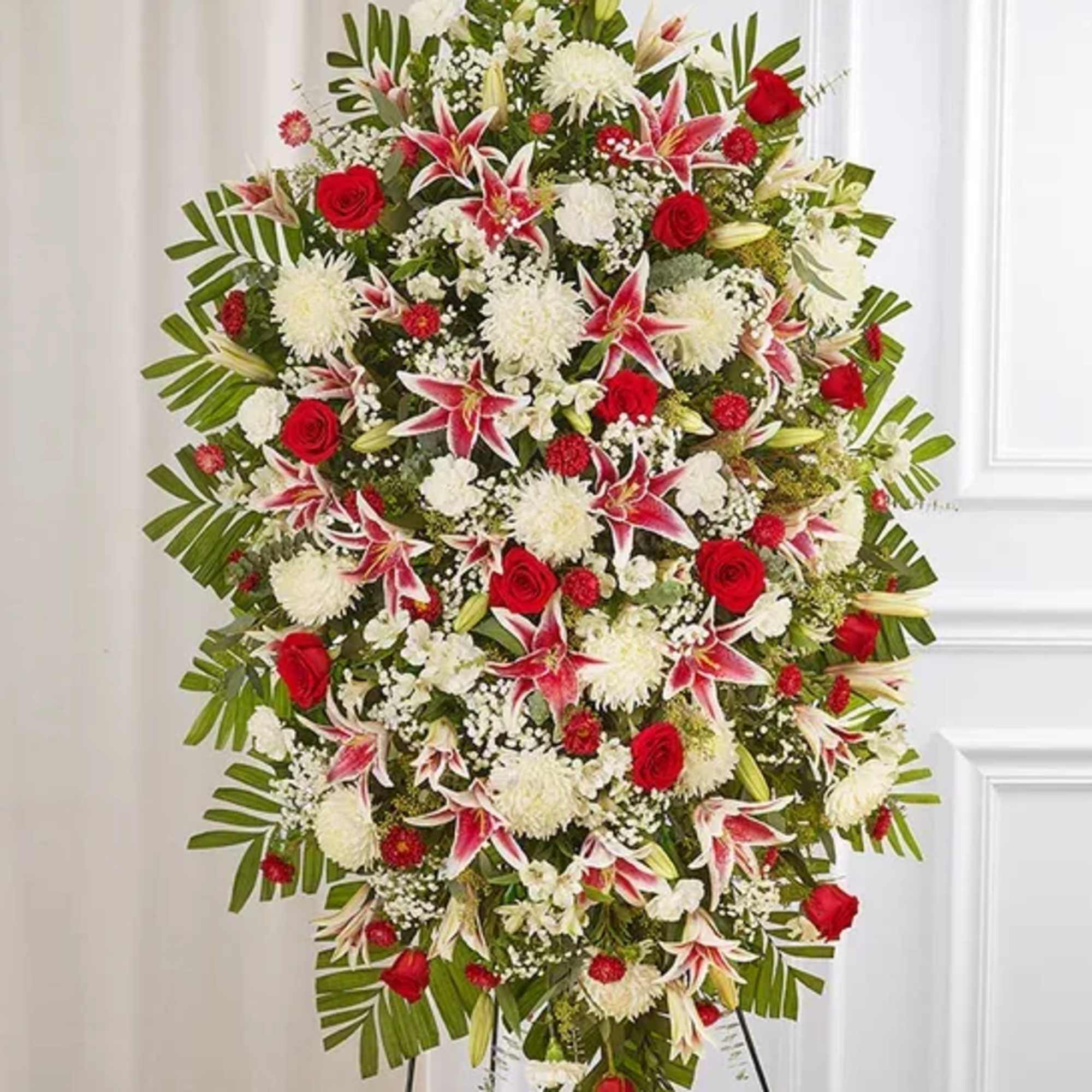 Large standing floral spray with red roses, white blooms, and pink lilies