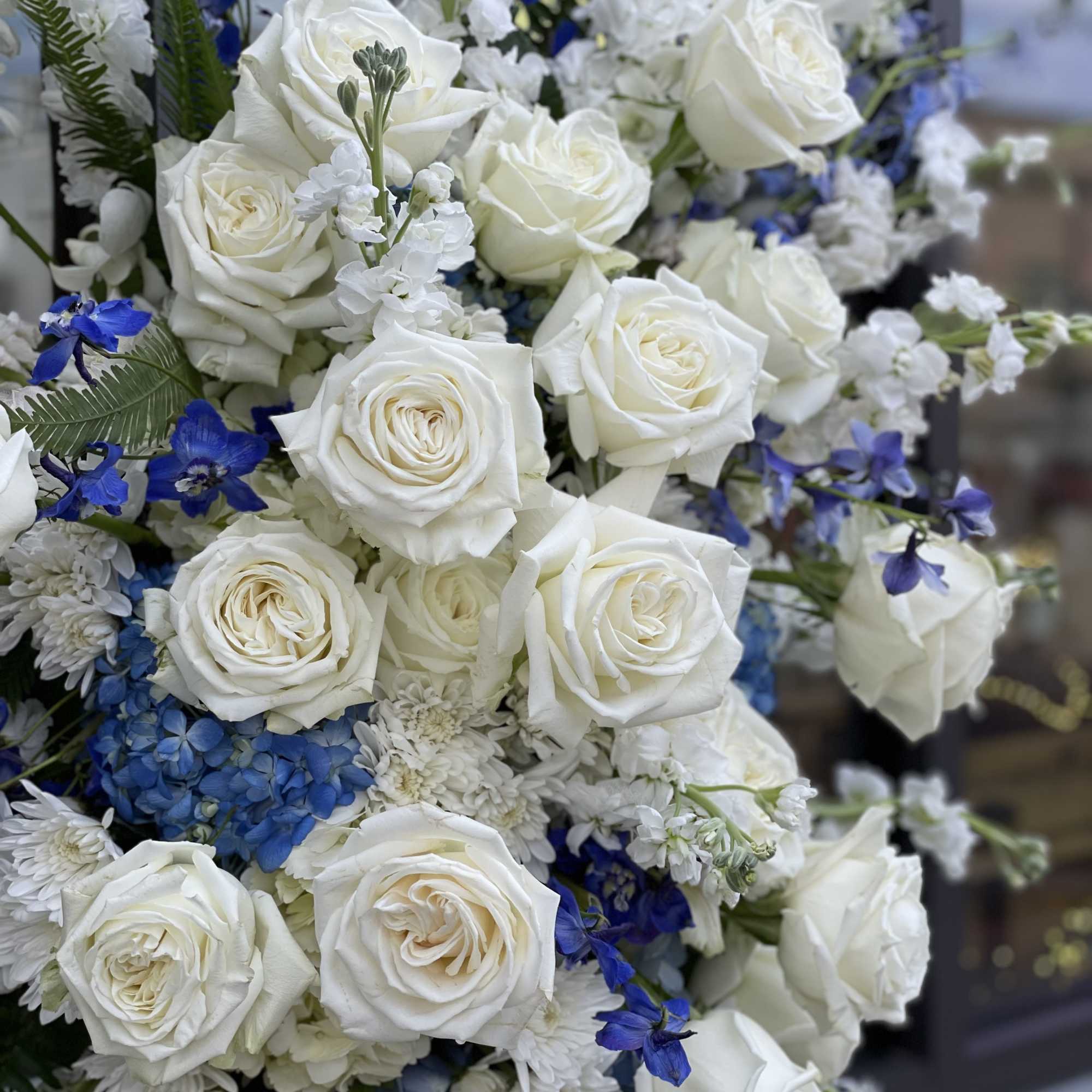 White roses with blue and white flowers in a dense bouquet