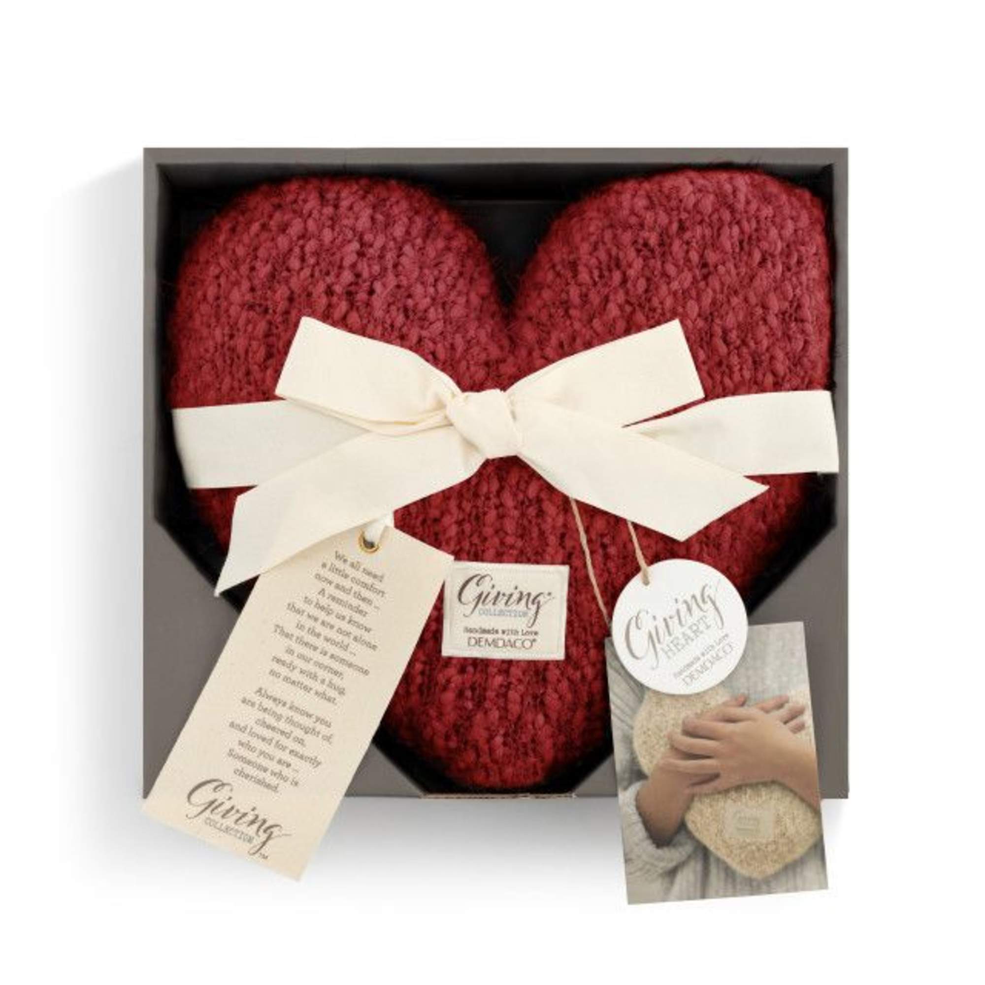 Red knitted heart gift in a box with a white ribbon and tags