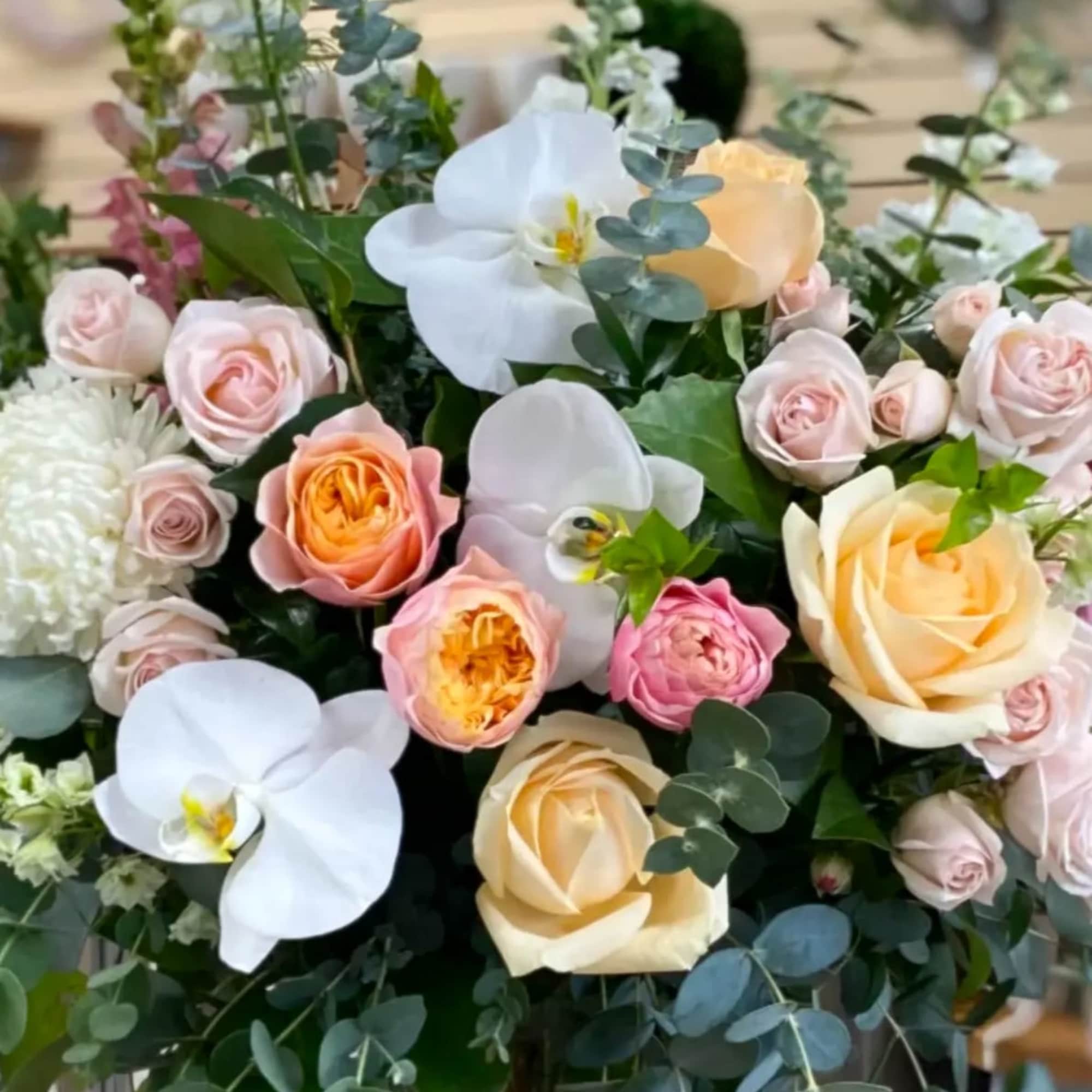 Bouquet of pale roses and white orchids with eucalyptus