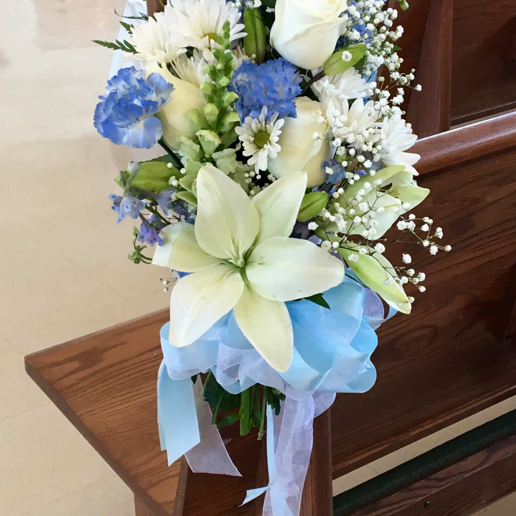 White and blue floral bouquet with a light blue ribbon