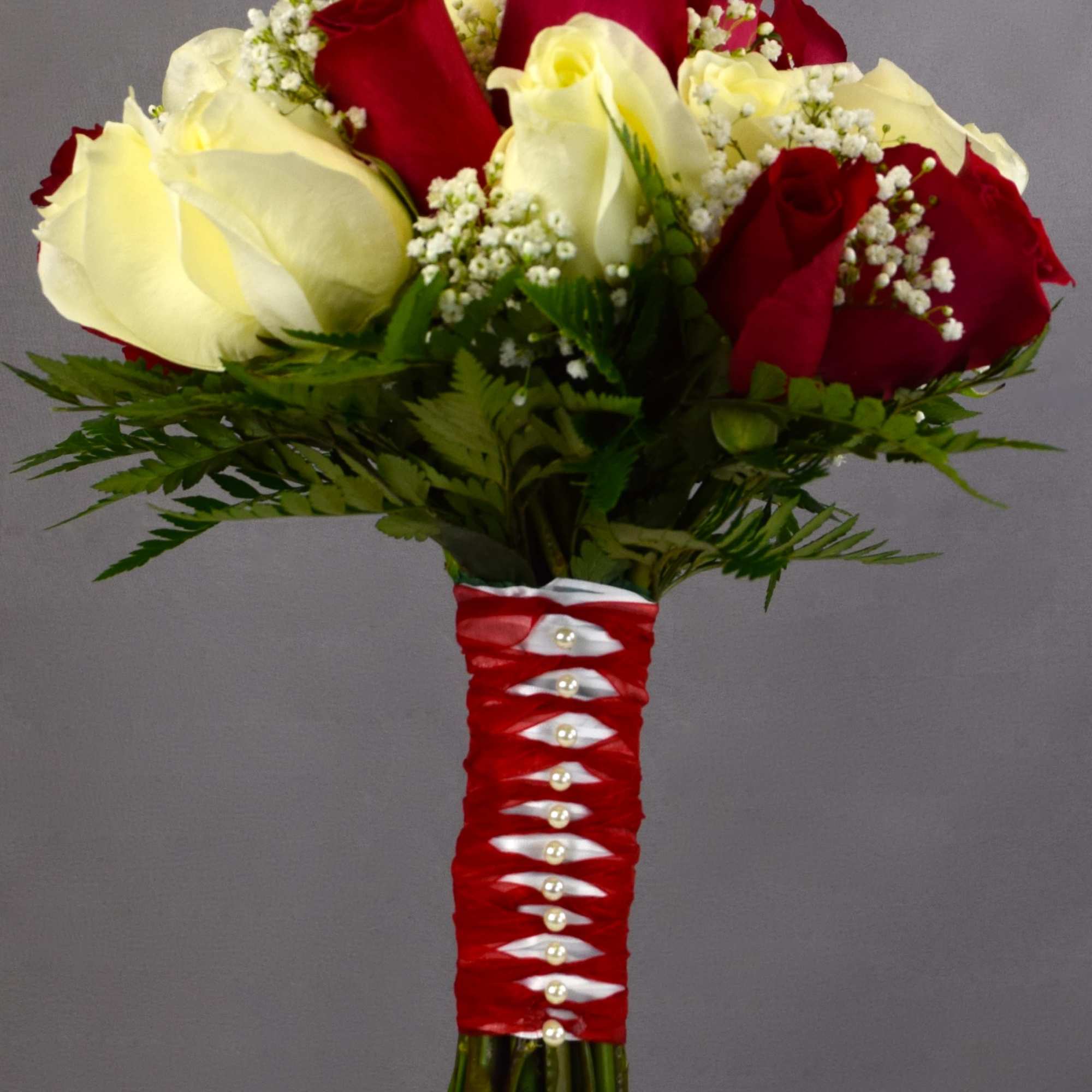 Bouquet of red and white roses with baby's breath in a decorated handle
