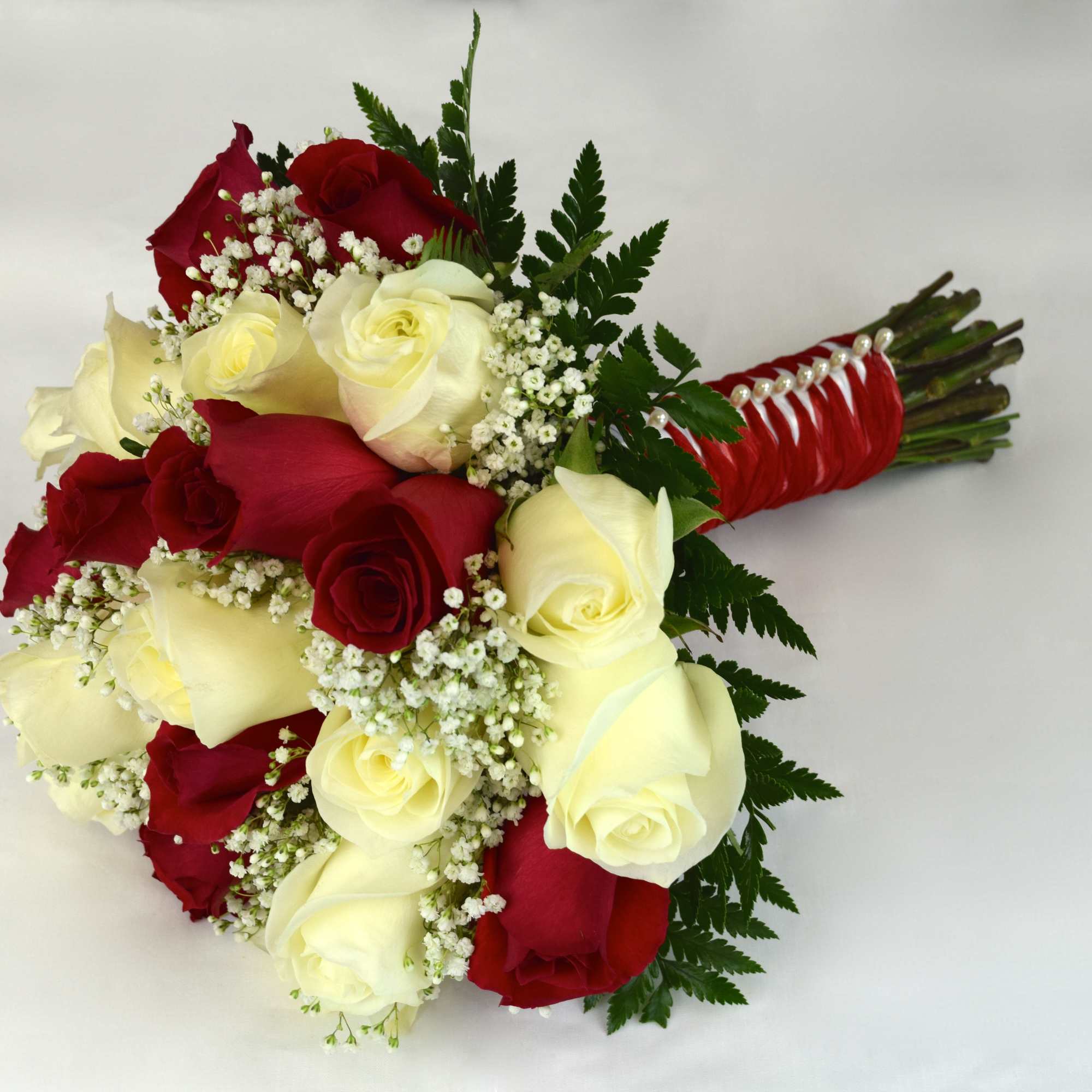 Bouquet of red and white roses with baby's breath and fern foliage