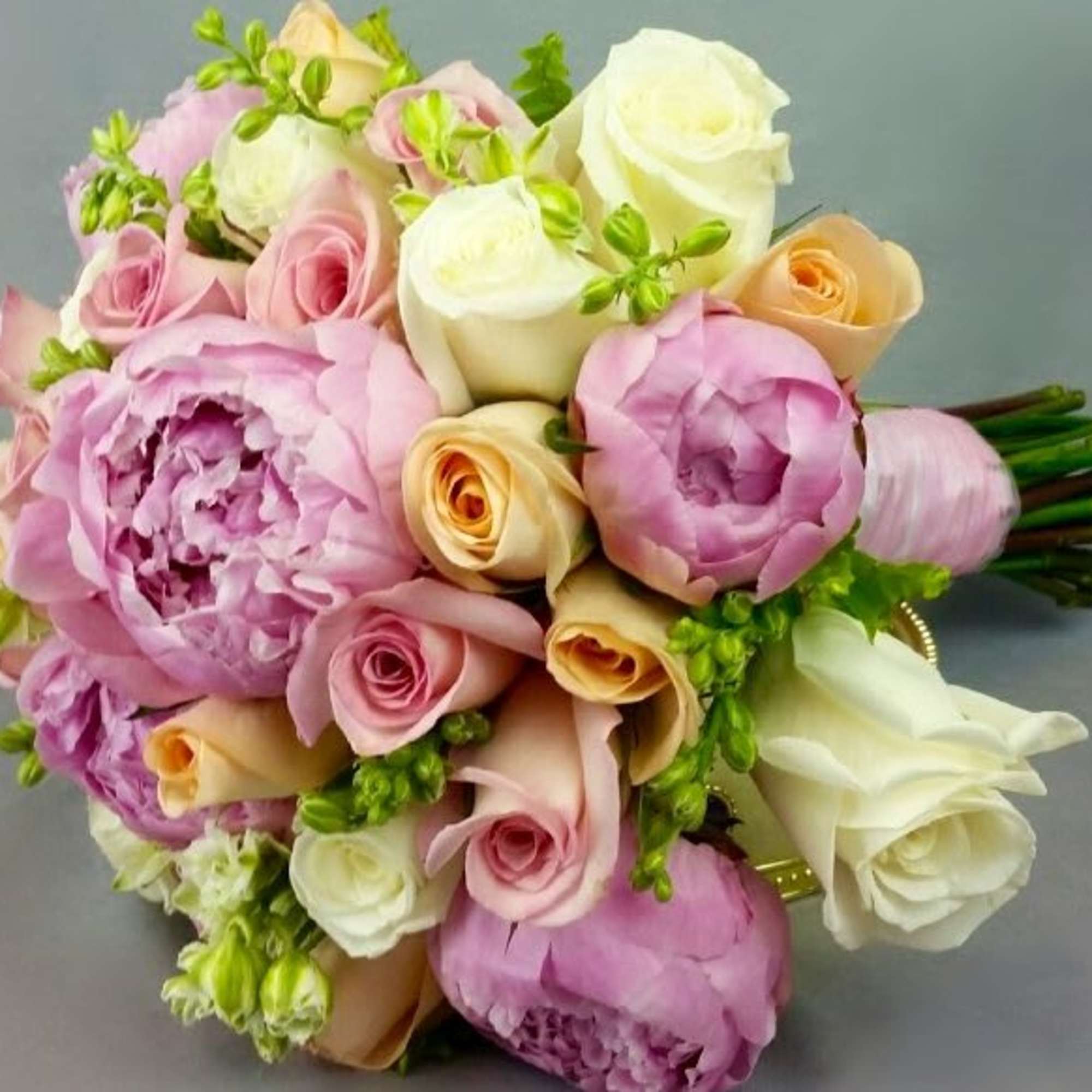 Bouquet of pink, white, and peach roses with lavender peonies