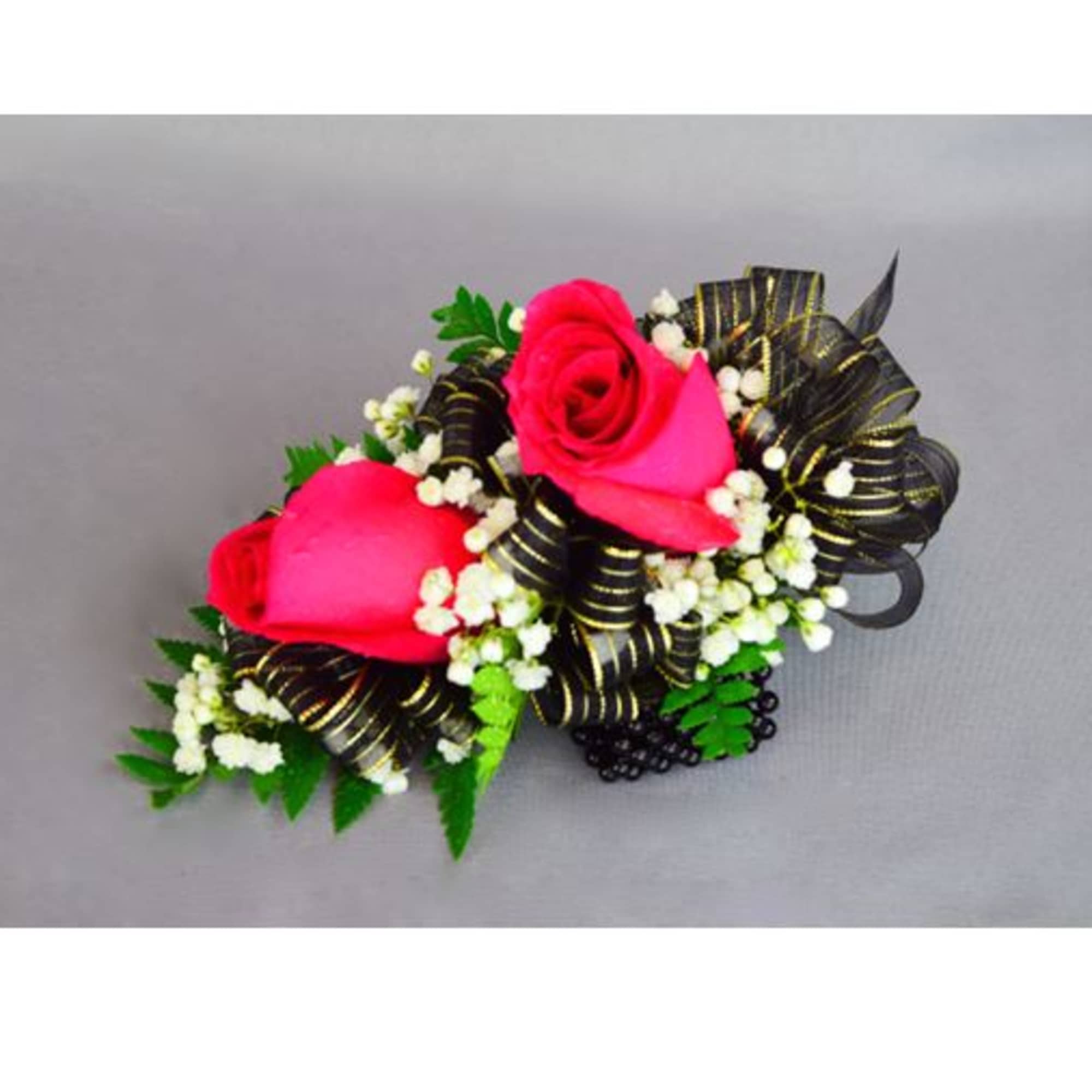 Two pink rose corsages with black ribbon and white filler flowers