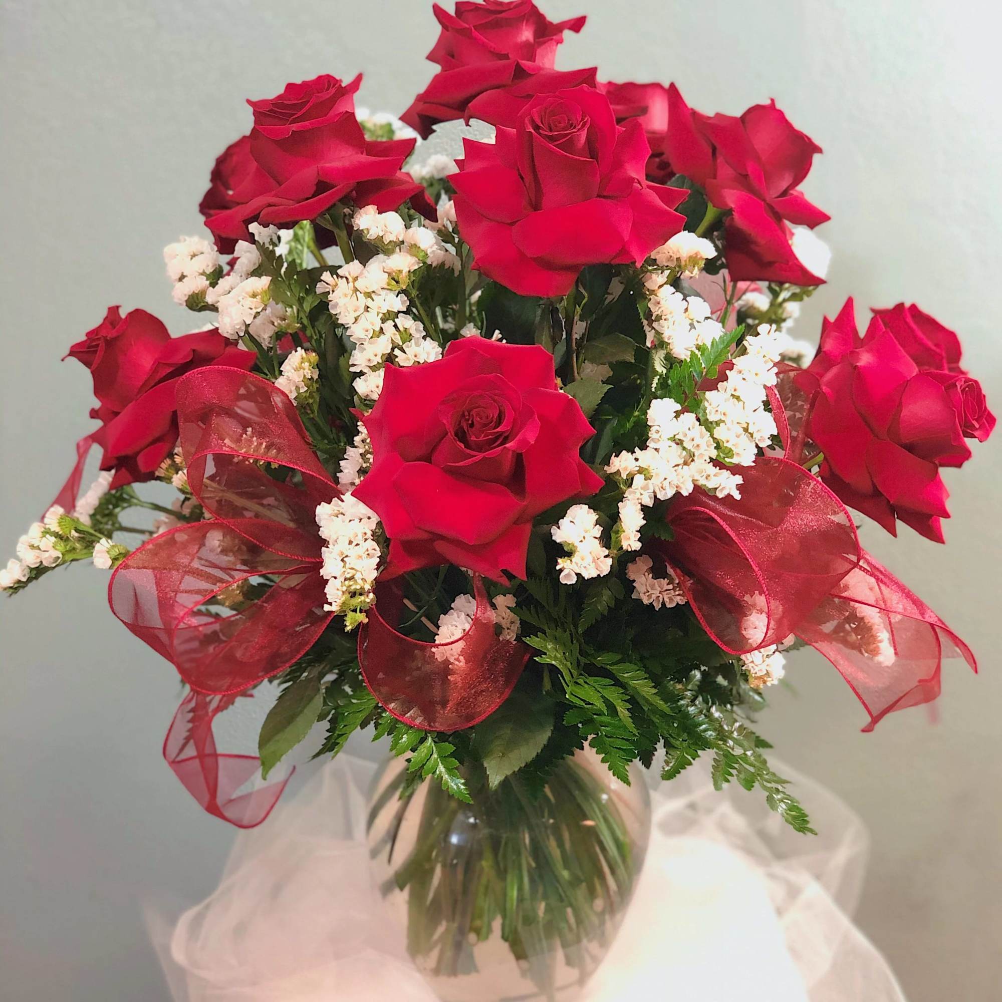 Bouquet of red roses with white filler flowers in a glass vase