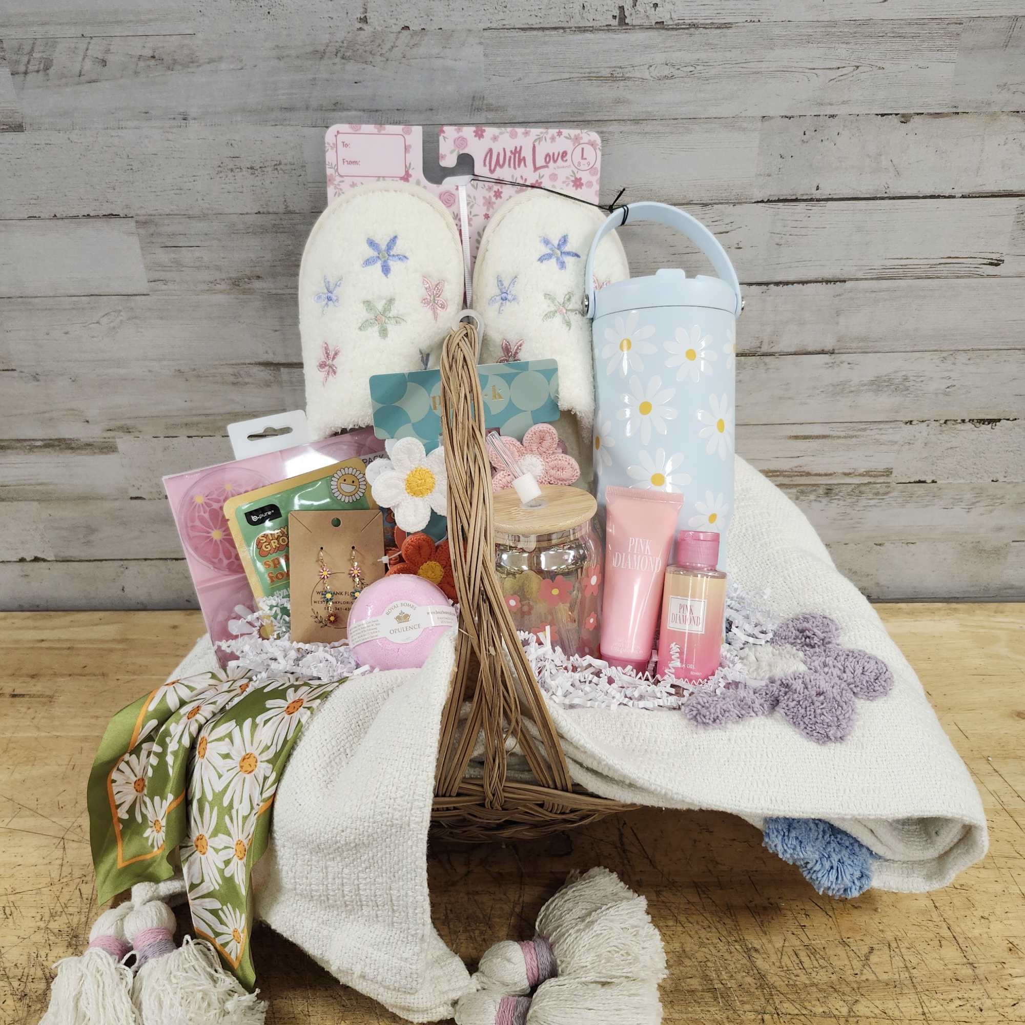 Gift basket with slippers, tumbler, bath items, and a scarf