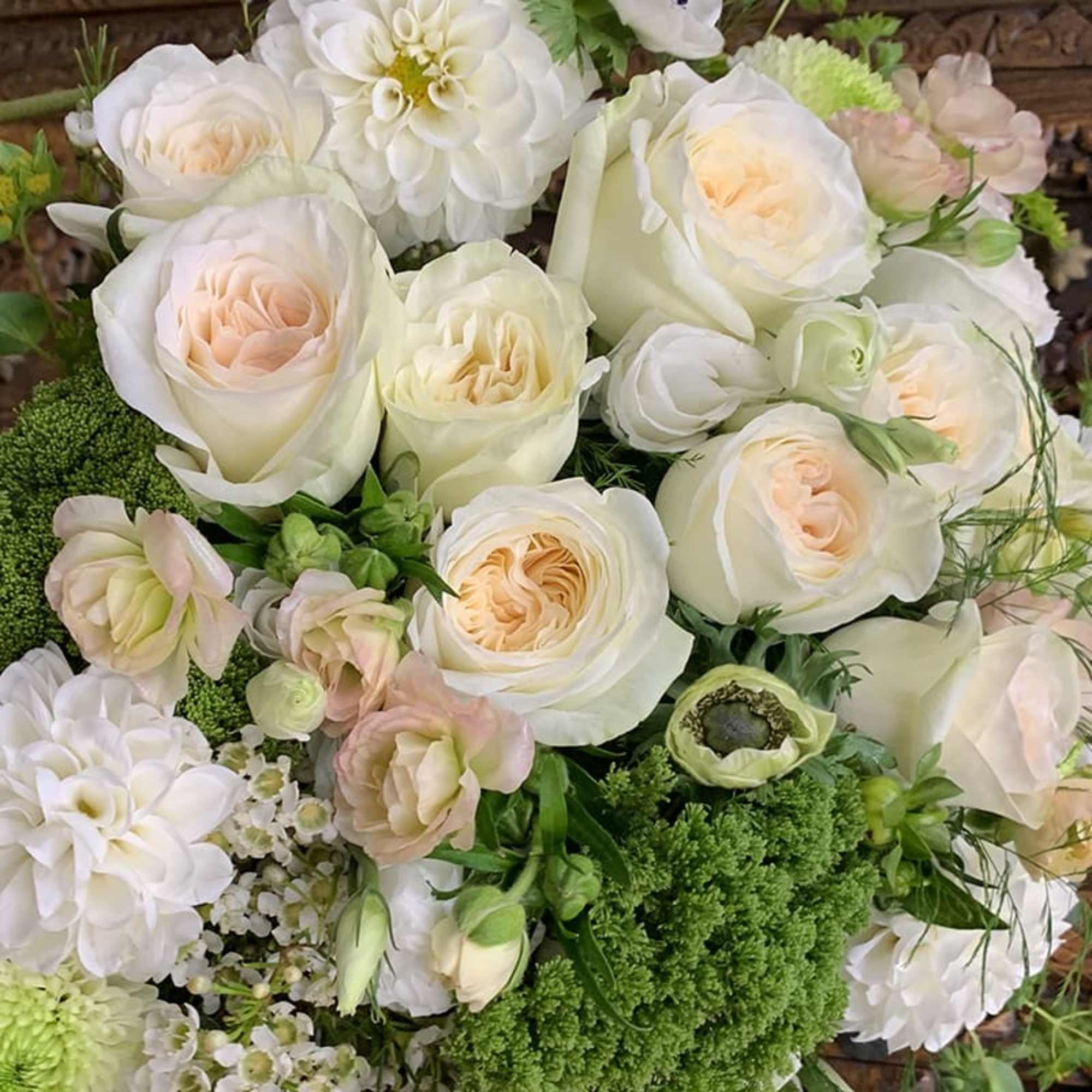 Bouquet of white and blush roses with white dahlias and green filler flowers