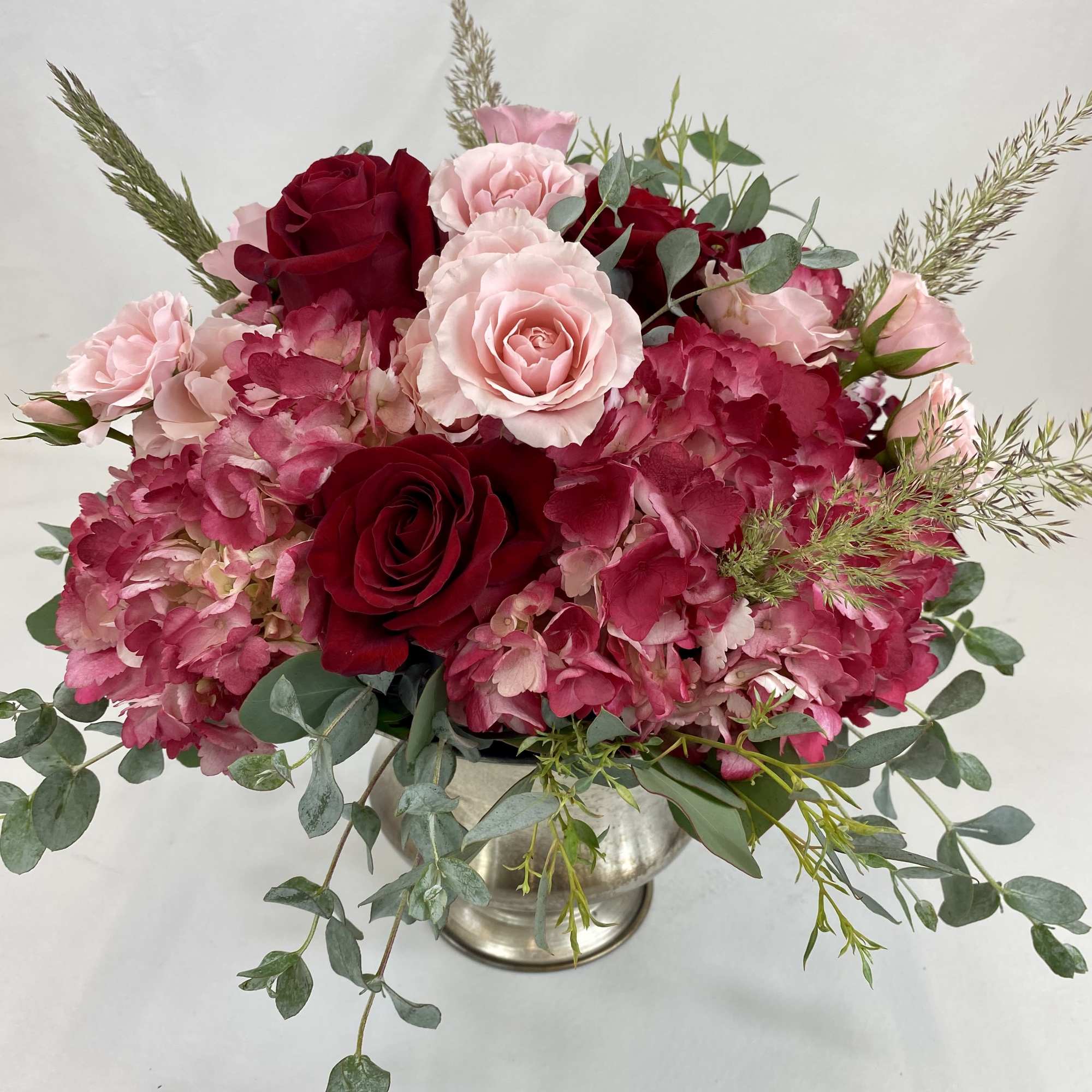 Elegant flower arrangement with red hydrangeas, roses, spray roses and mix of