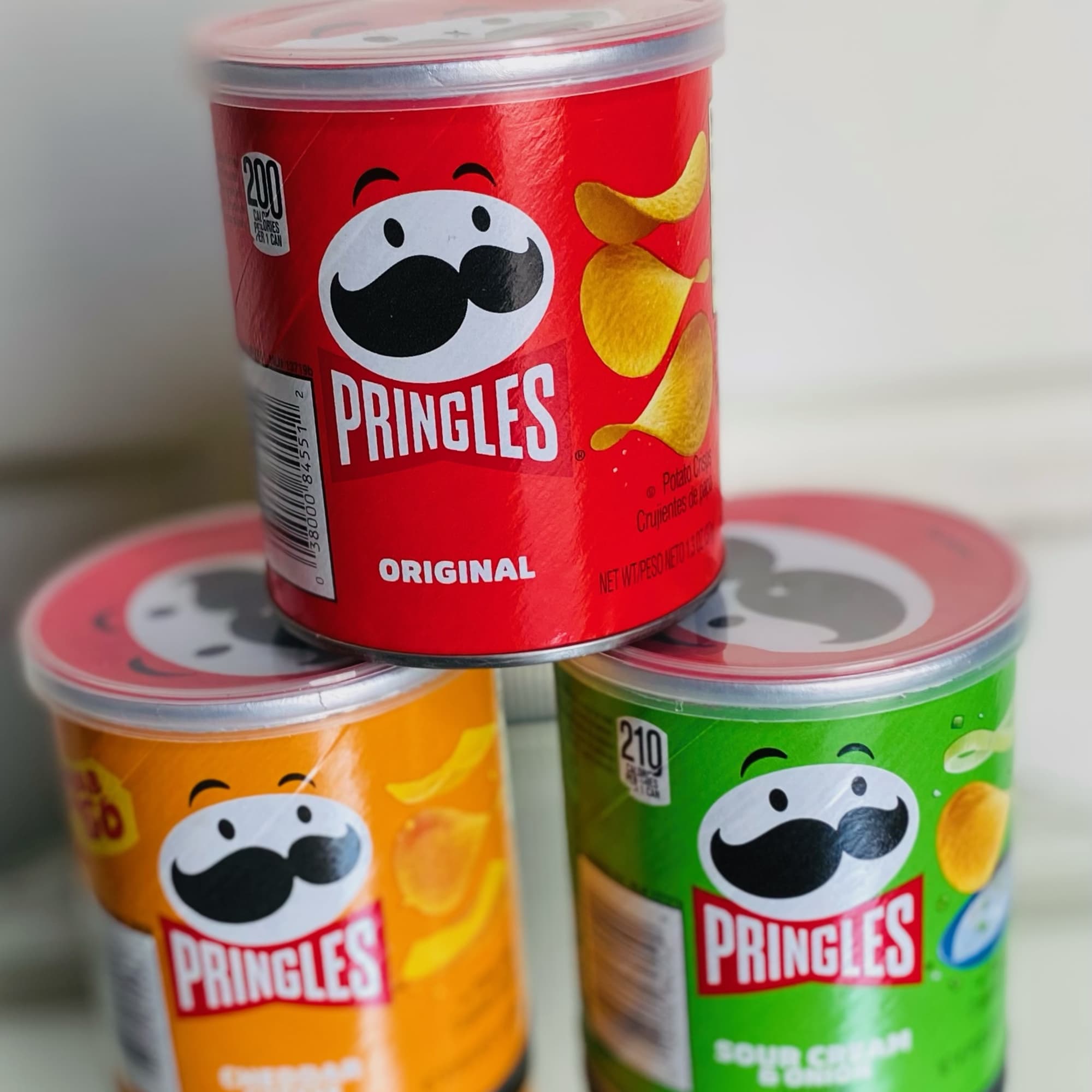 Stack of three Pringles cans in red, orange, and green