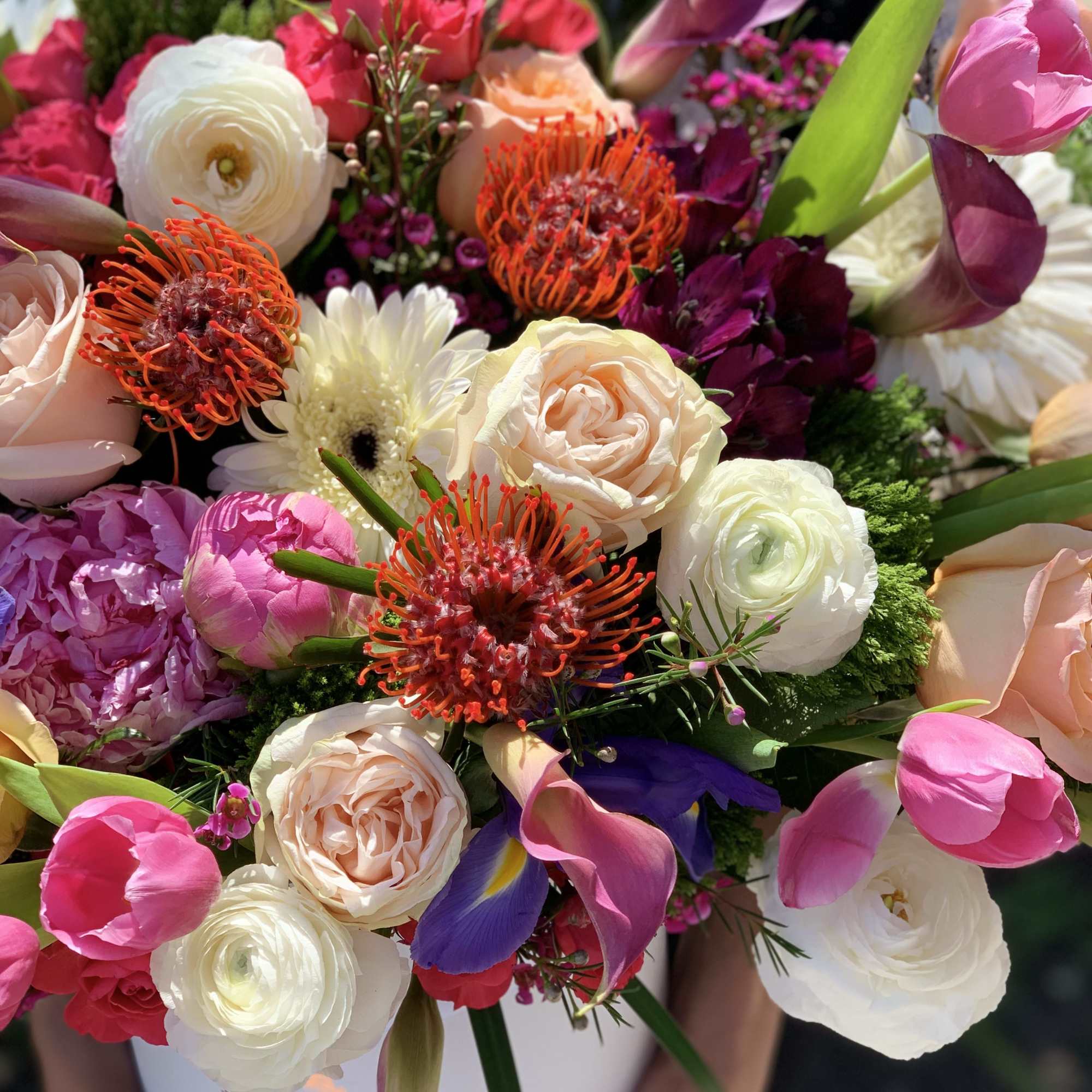 Mixed bouquet of pink, white, and peach flowers with purple accents