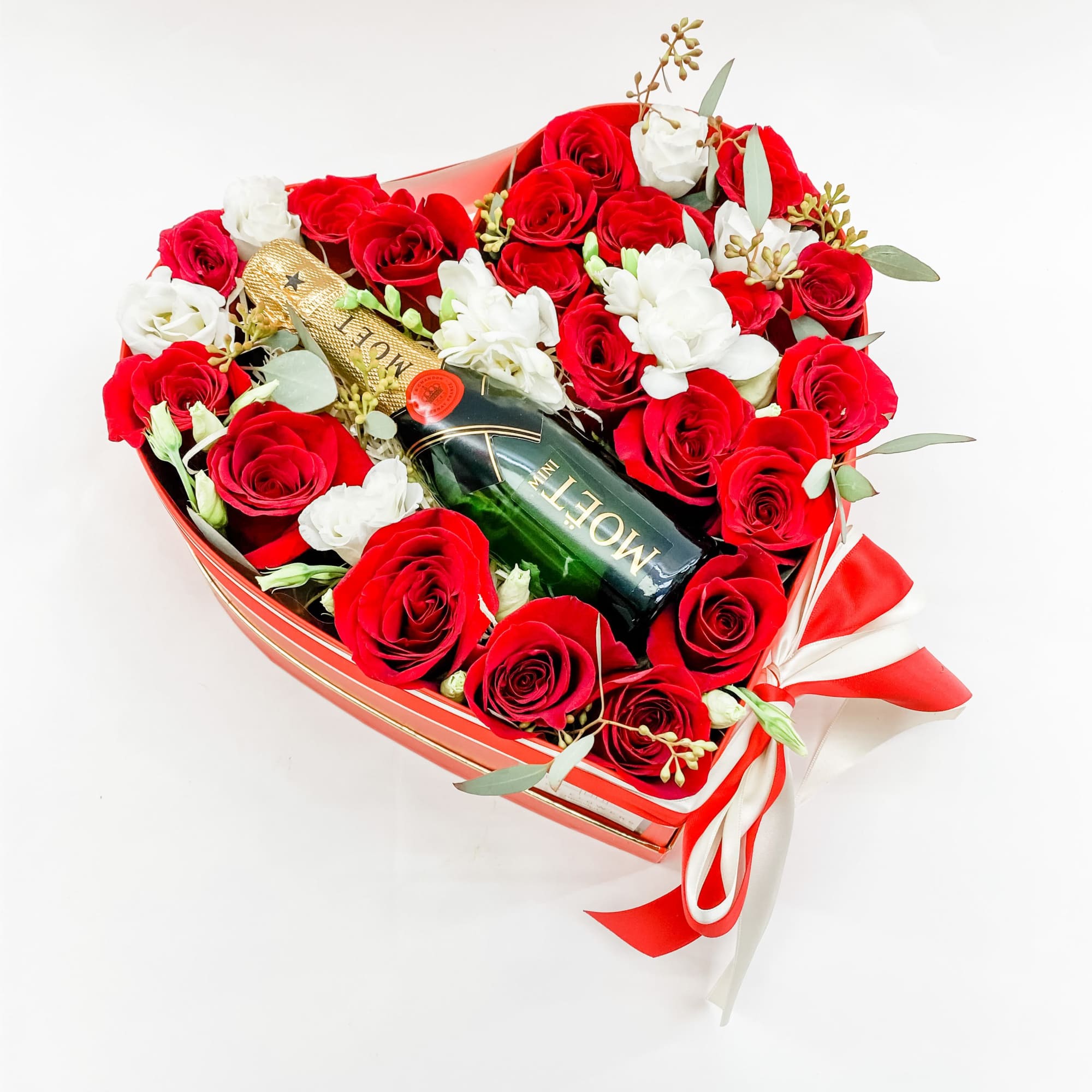 Heart-shaped box of red and white roses with a champagne bottle