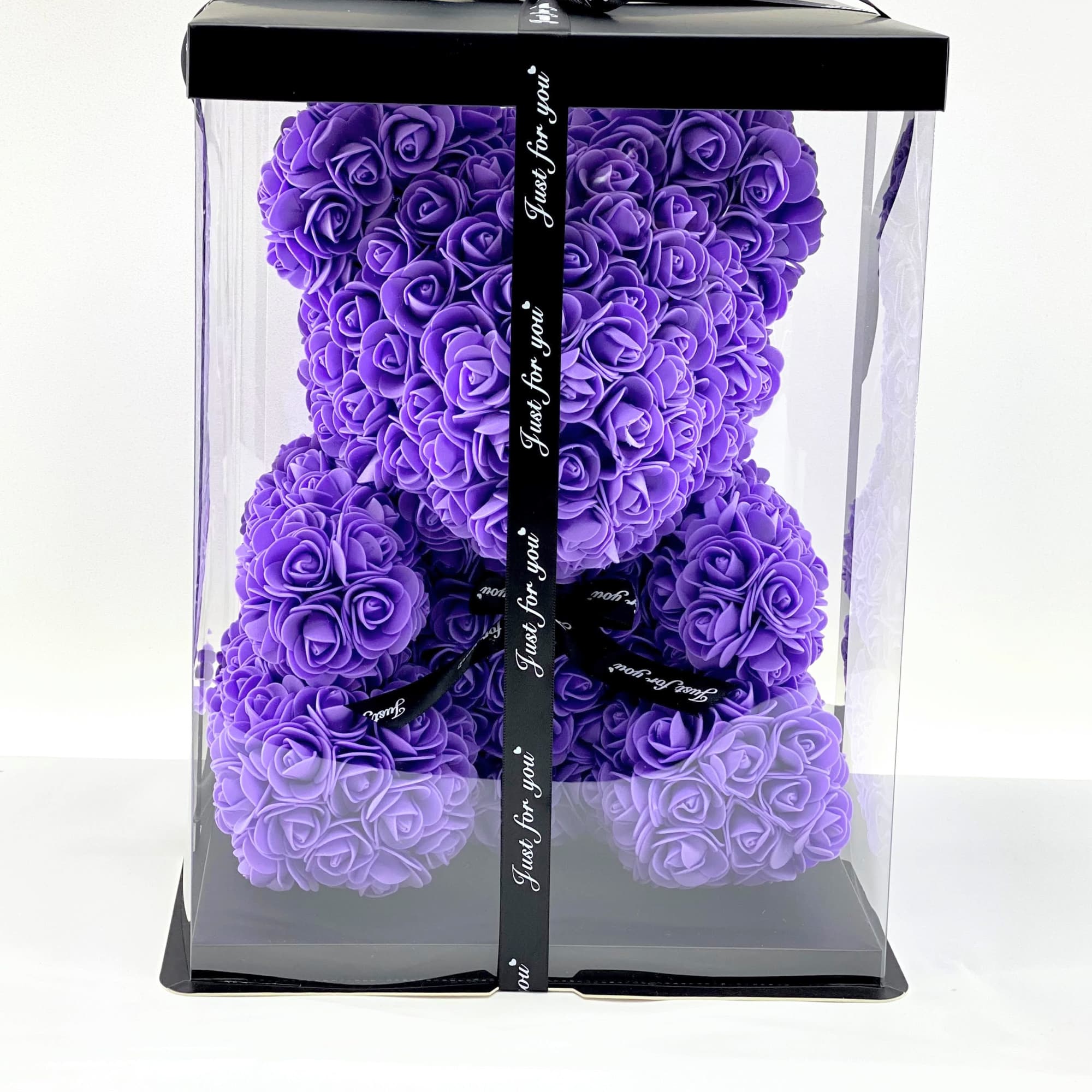 Purple rose teddy bear in a clear gift box with black ribbon
