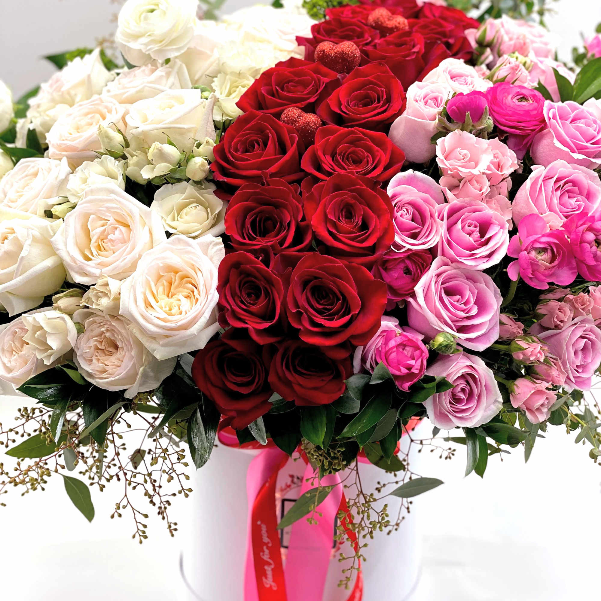 Large bouquet of red, pink, and white roses in a white hat box