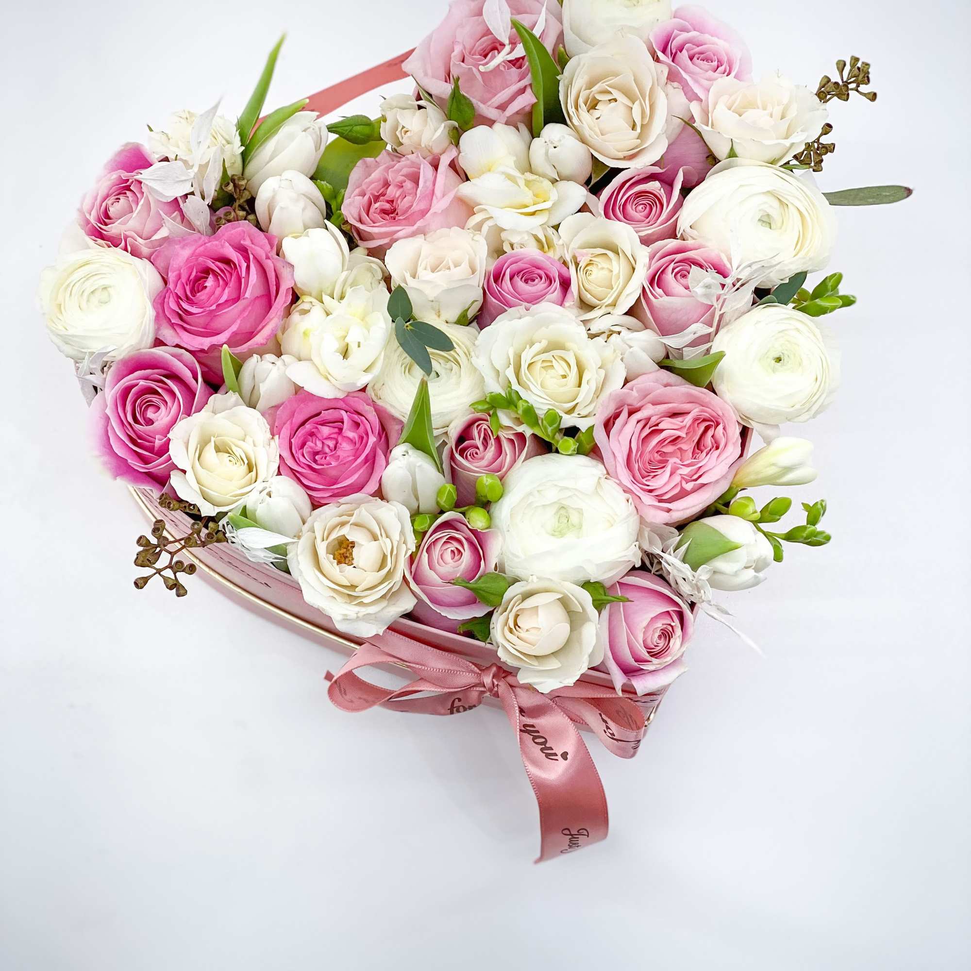 Pink and white rose bouquet in a heart-shaped box with ribbon