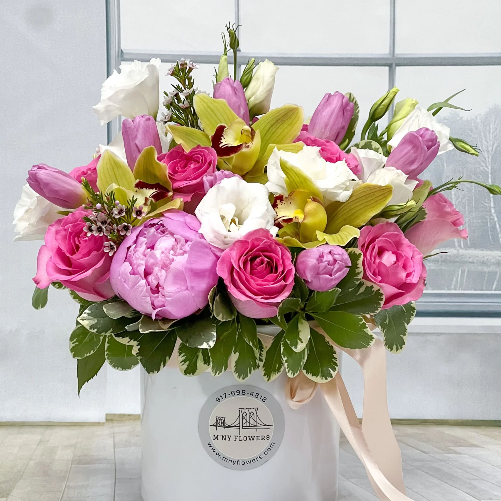 Pink and white bouquet with orchids and roses in a white box