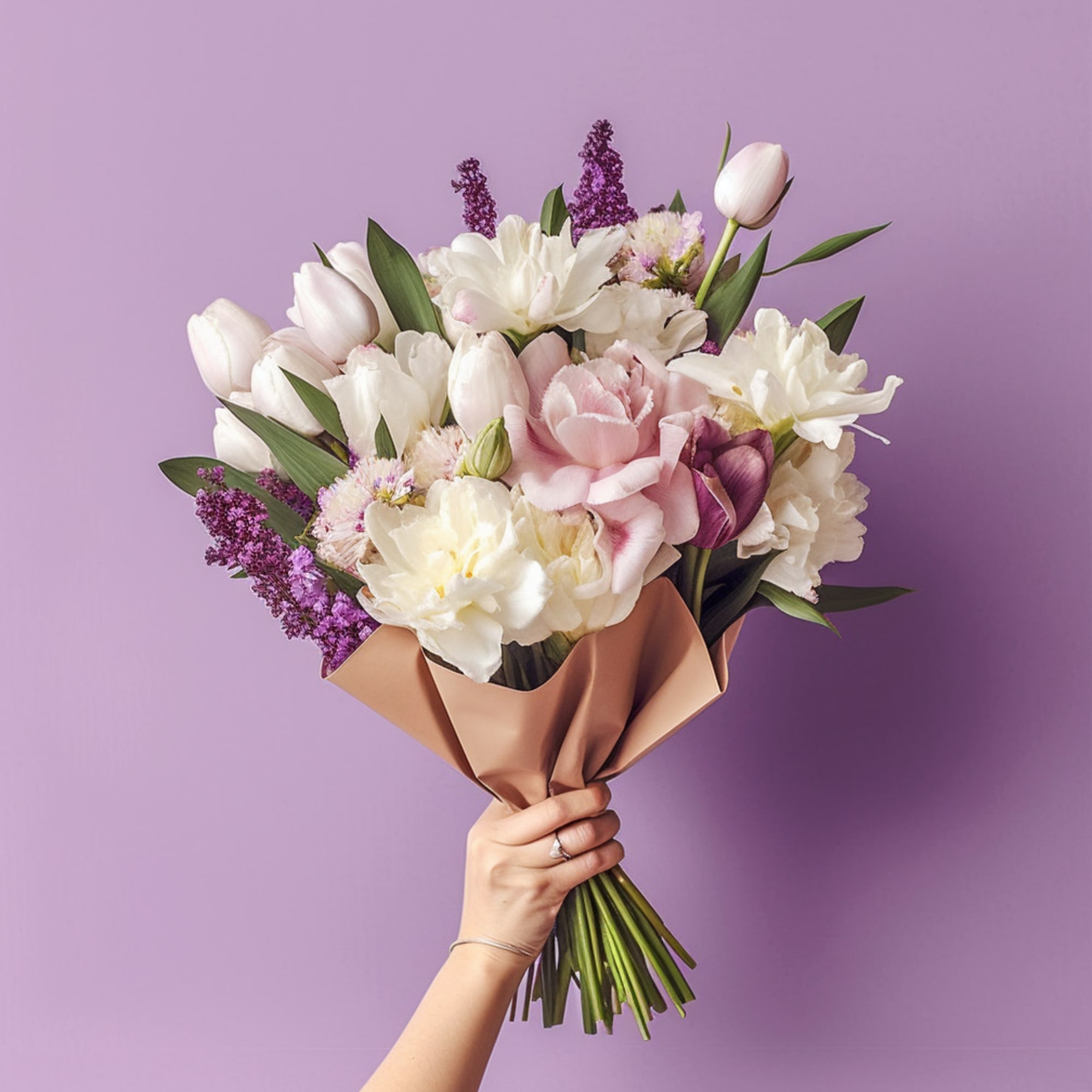 Handheld bouquet of pink, white, and purple flowers wrapped in tan paper