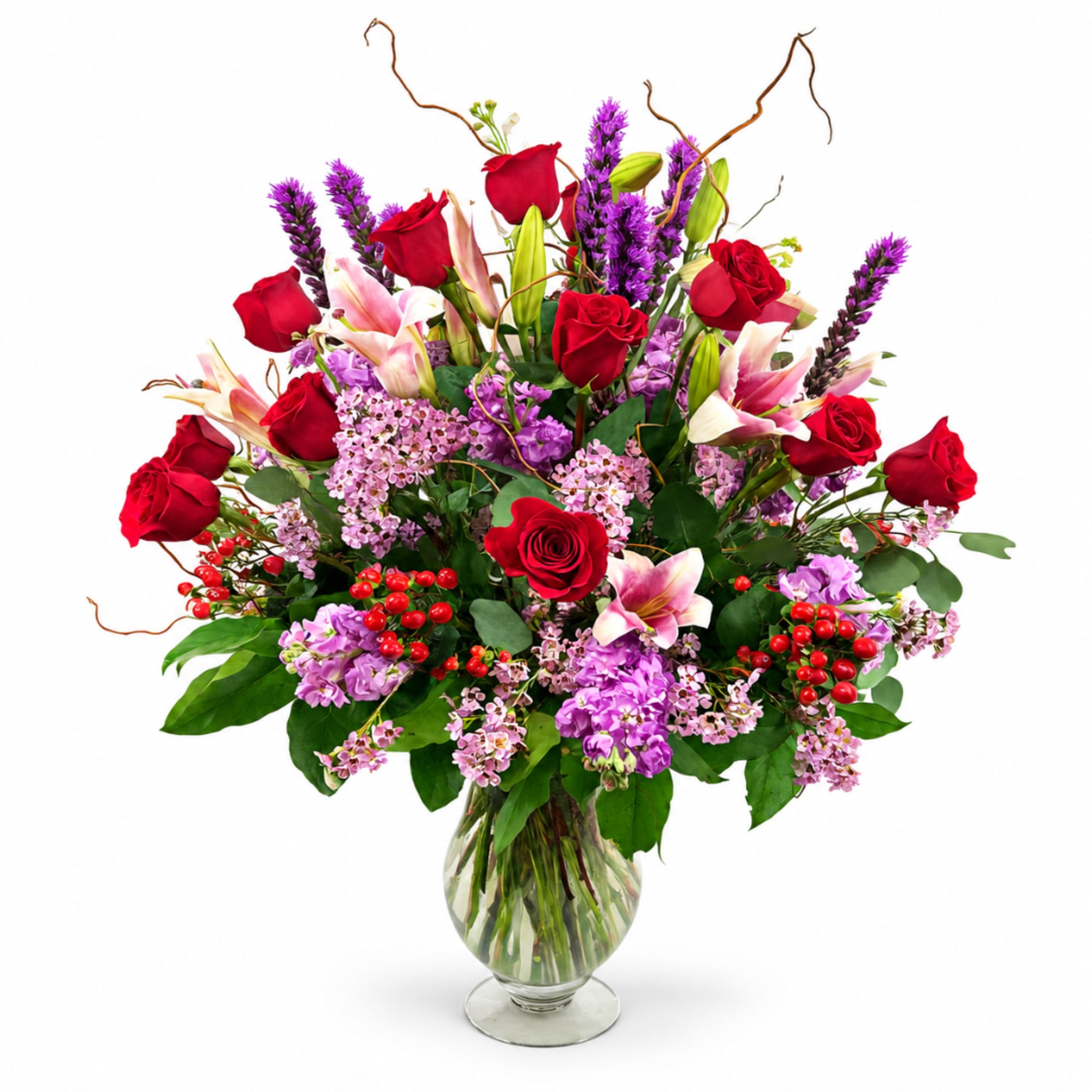 Red roses and pink lilies in a clear glass vase