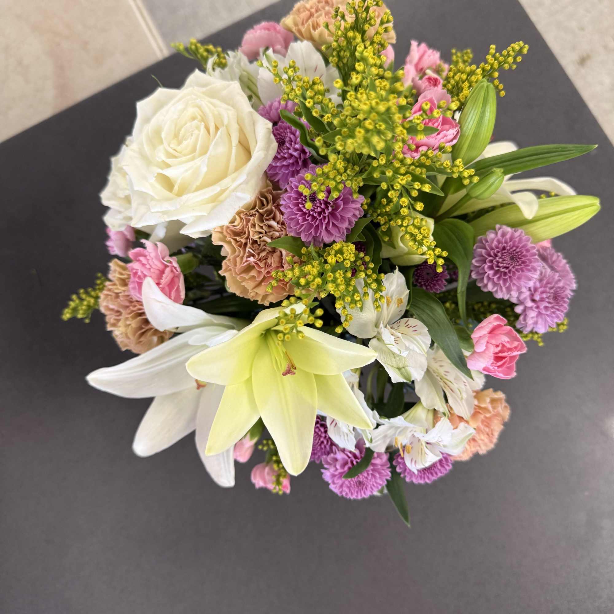 Soft pastels meet a modern blue glass vase in this charming flower, photo 2 of 3