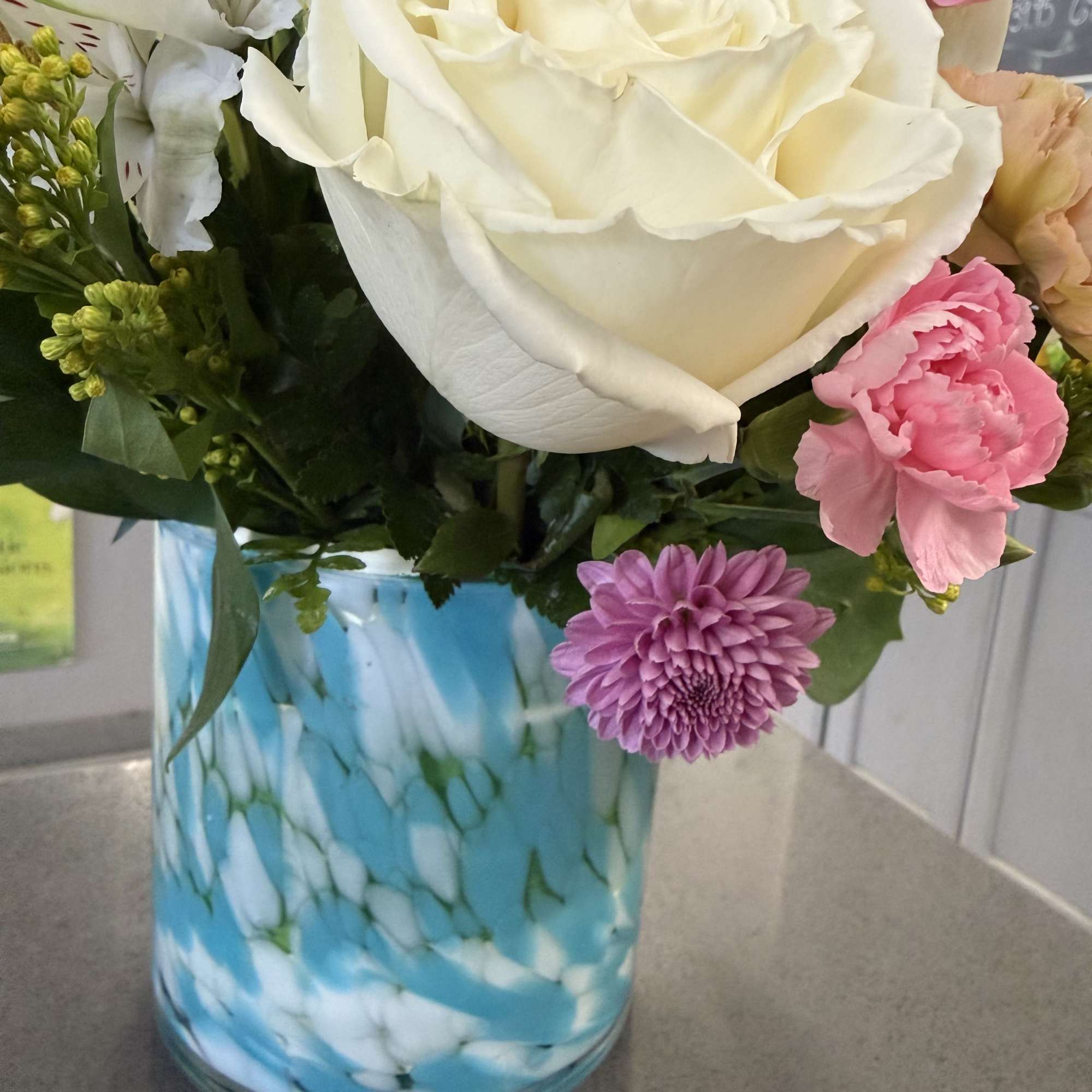 Soft pastels meet a modern blue glass vase in this charming flower, photo 3 of 3