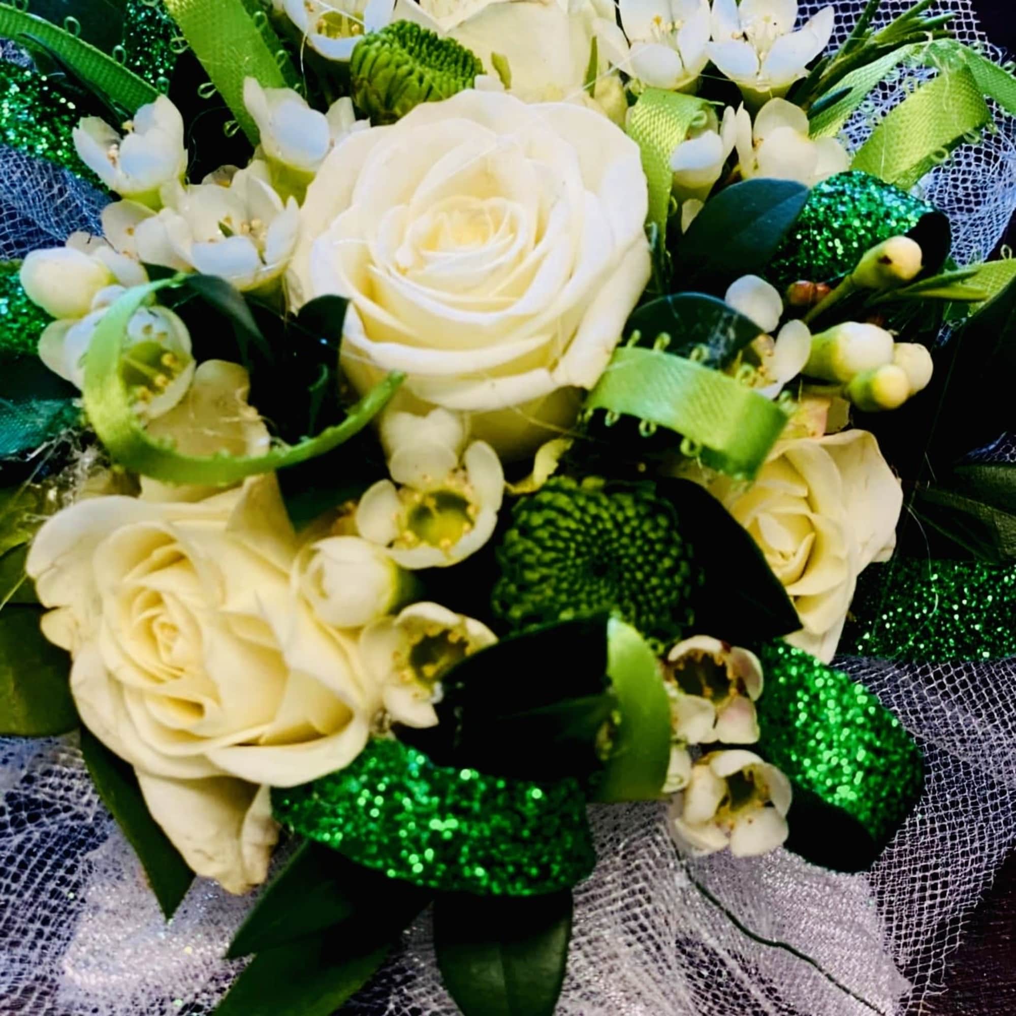 A timeless corsage featuring a pristine white rose nestled among fresh, lush, photo 4 of 5
