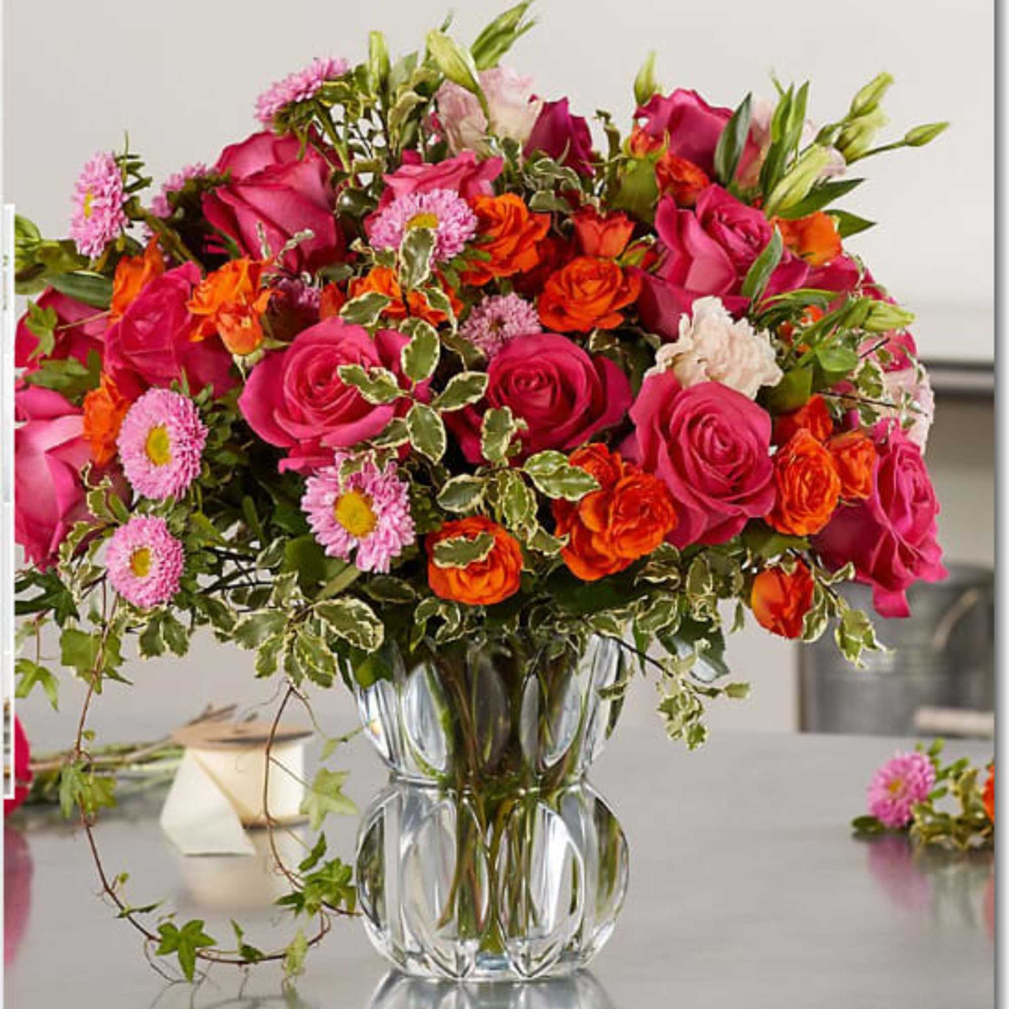 Bright mixed bouquet of pink and orange flowers in a clear glass vase
