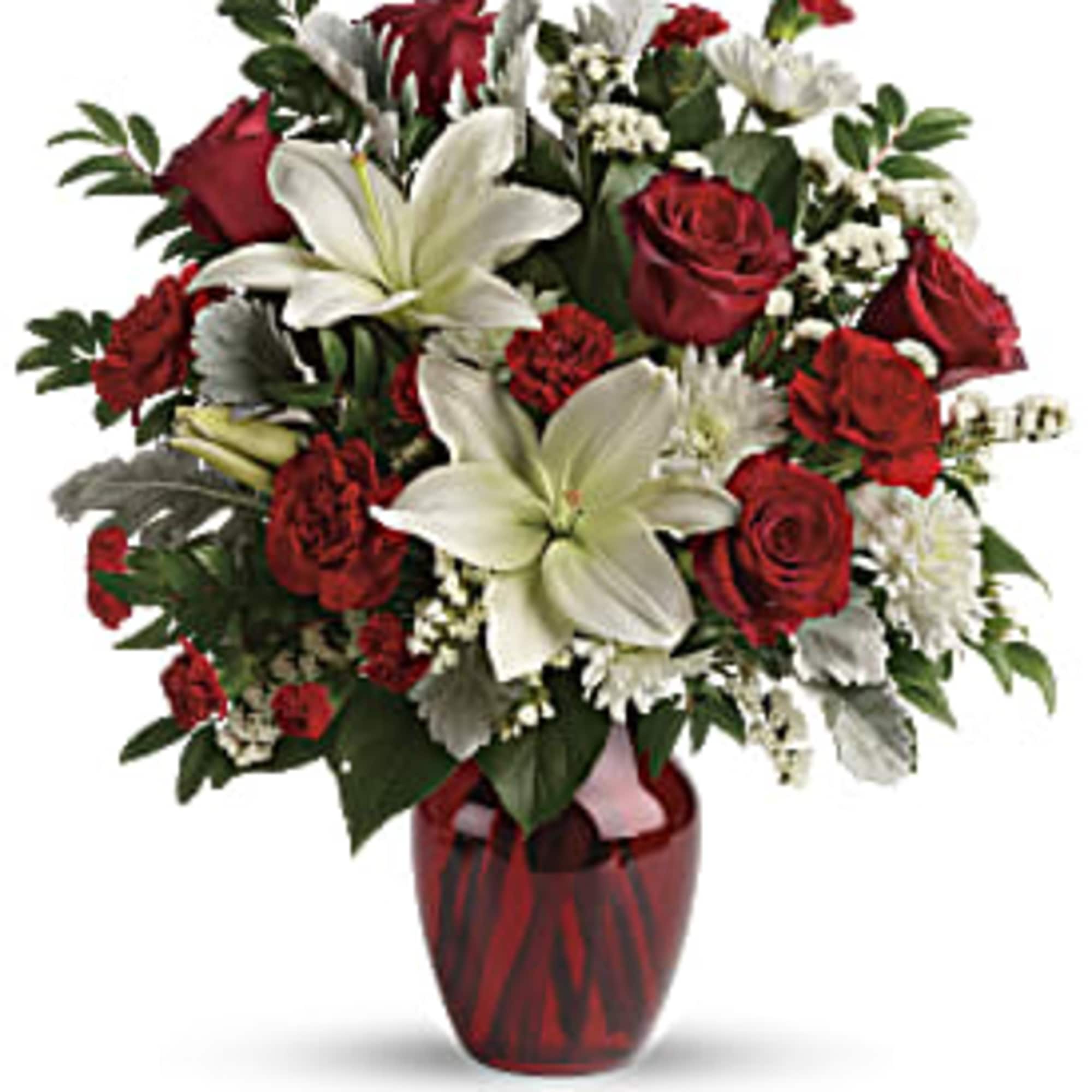 Red roses and white lilies arranged in a red glass vase