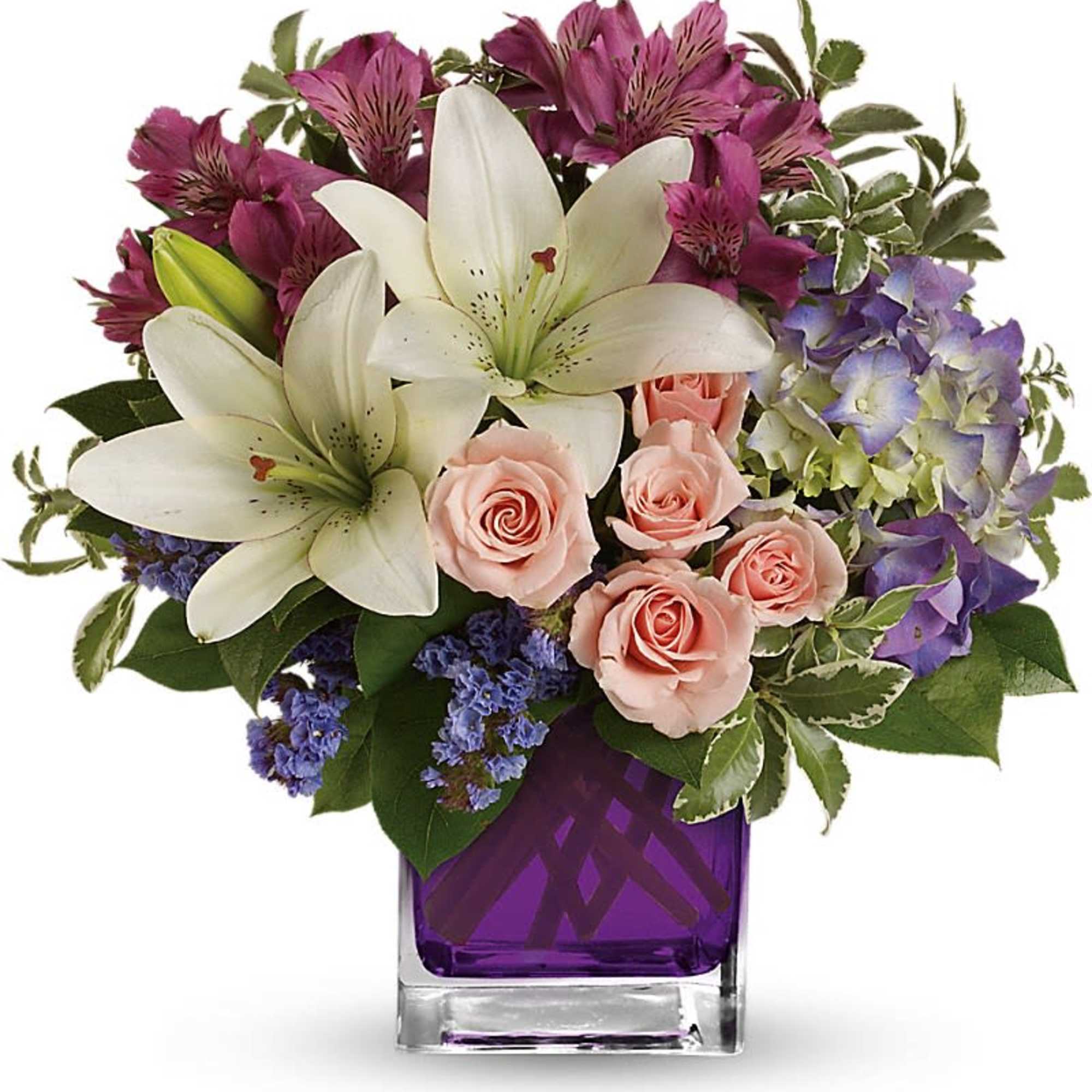 Bouquet of white lilies, pink roses, and purple flowers in a purple glass vase