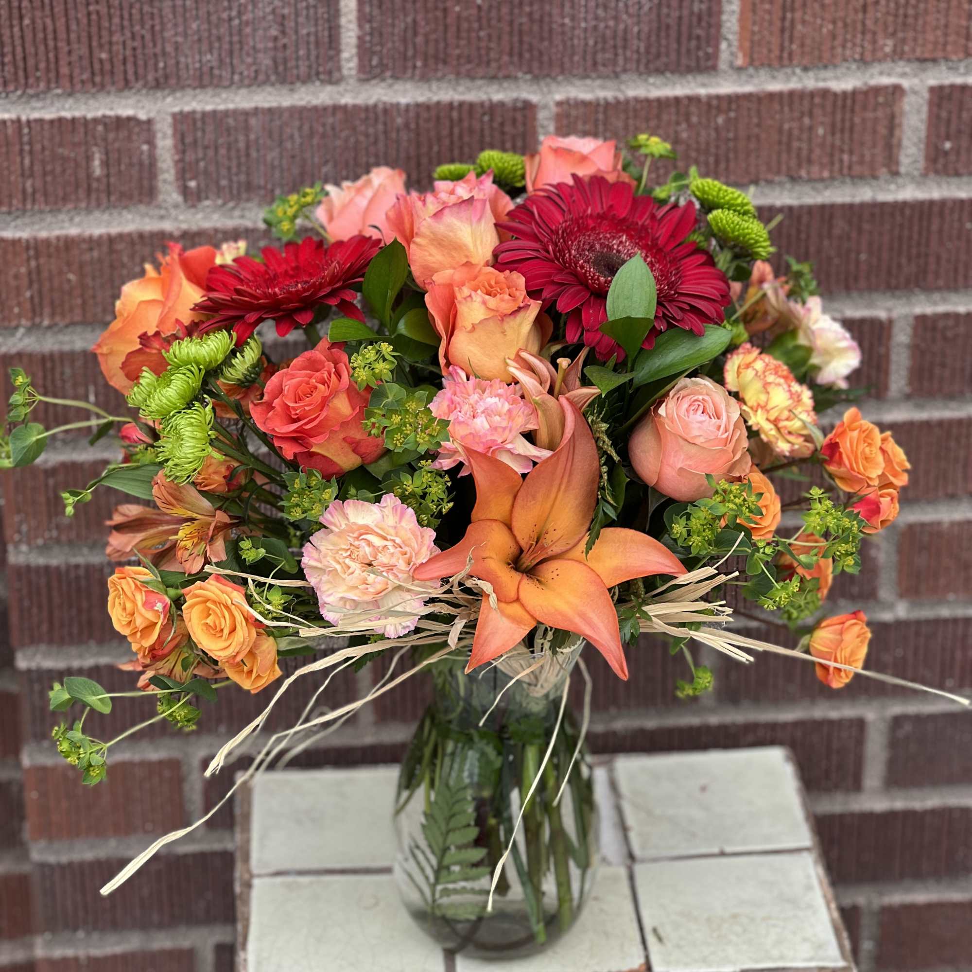 Bouquet of orange and pink flowers in a glass vase