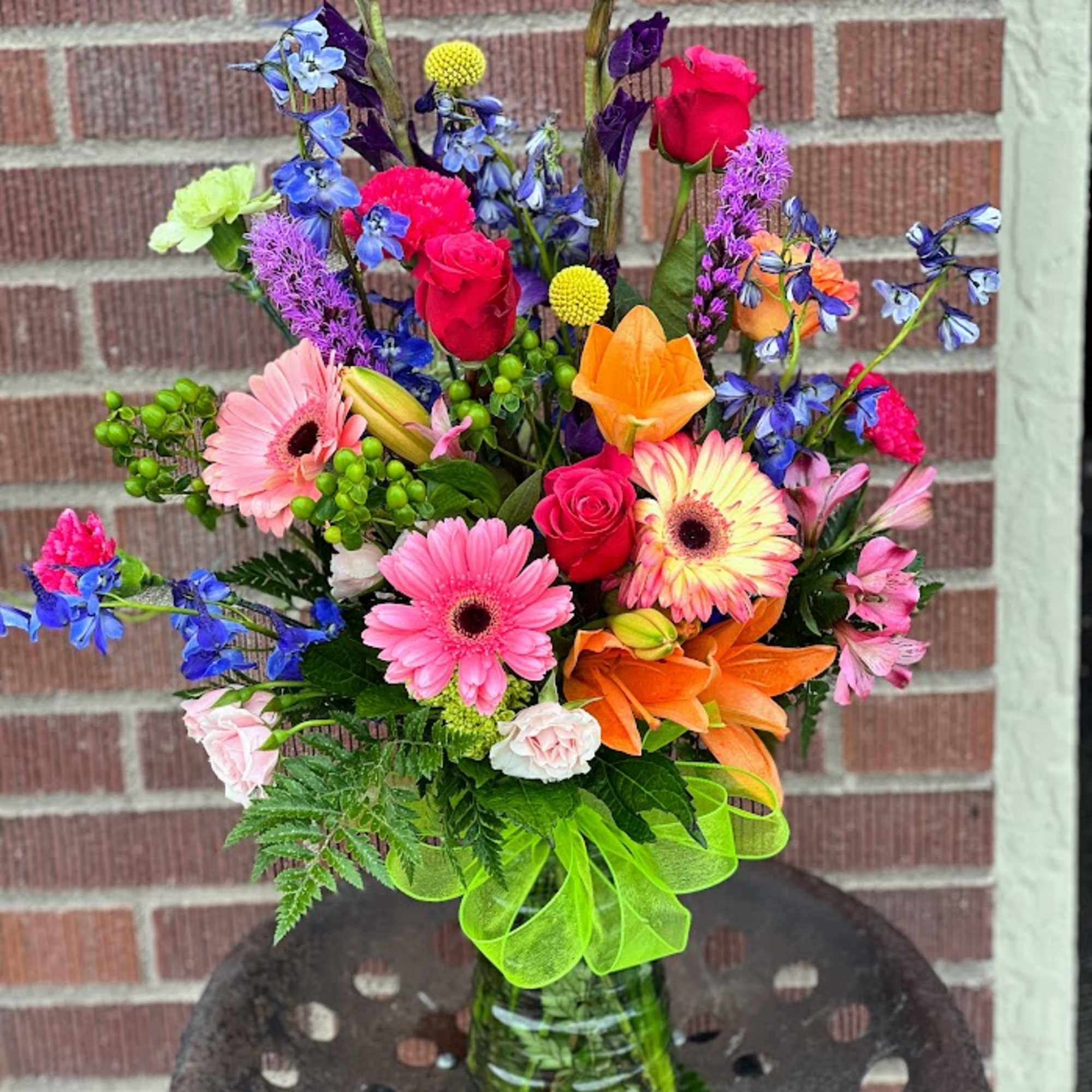 Colorful mixed bouquet in a glass vase with roses and gerbera daisies