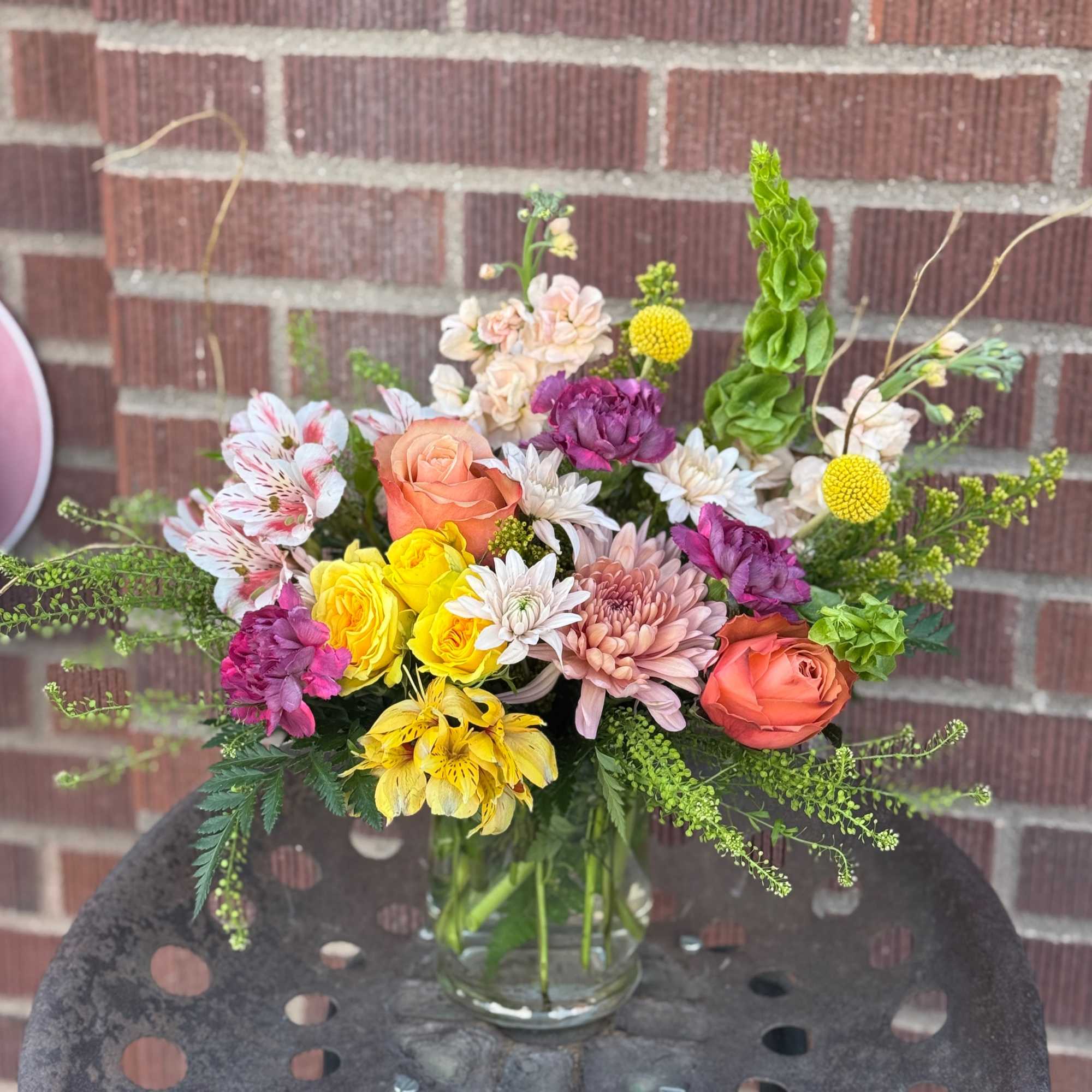Mixed bouquet in a clear glass vase with roses, chrysanthemums, and alstroemeria