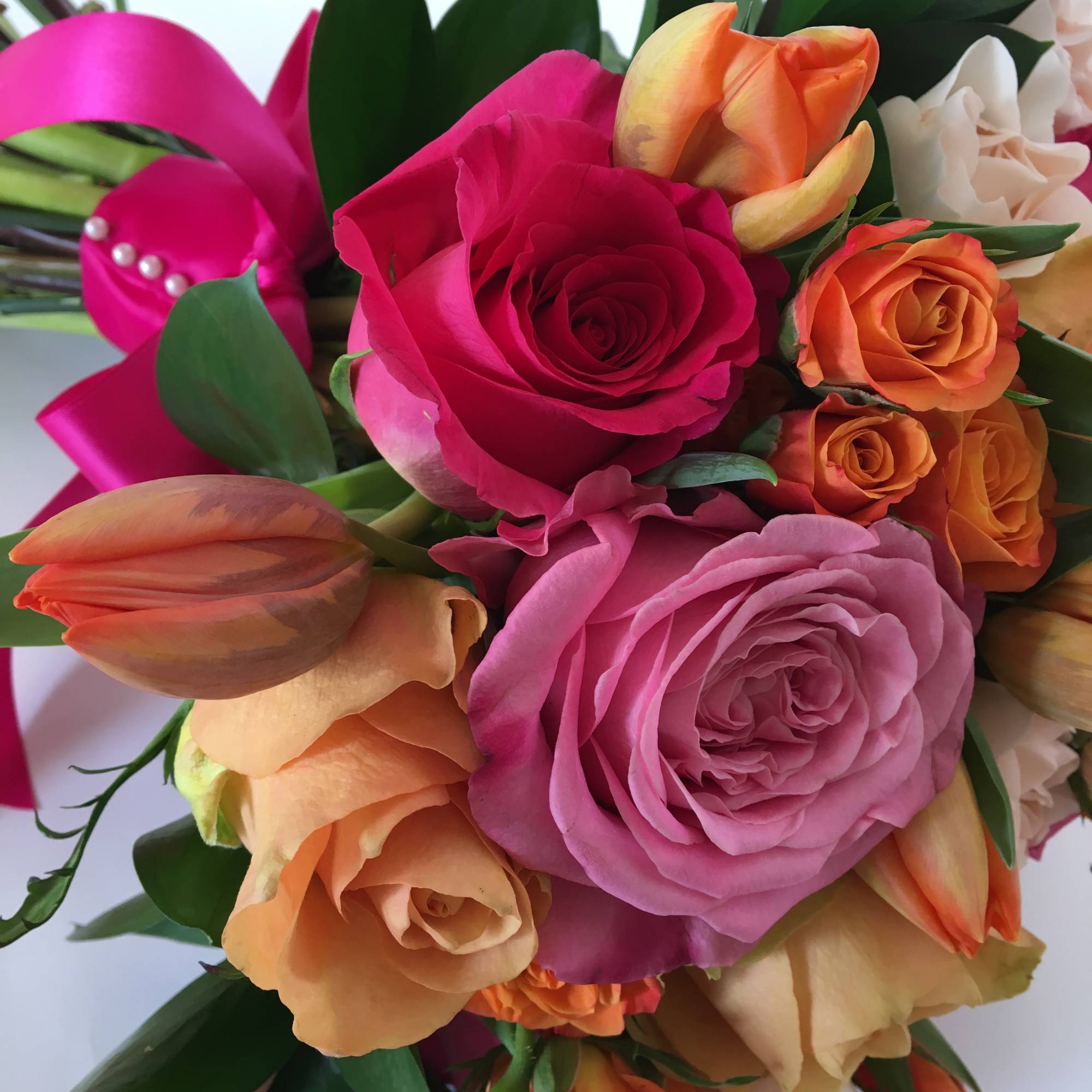 Bouquet of pink and orange roses with tulips and white flowers