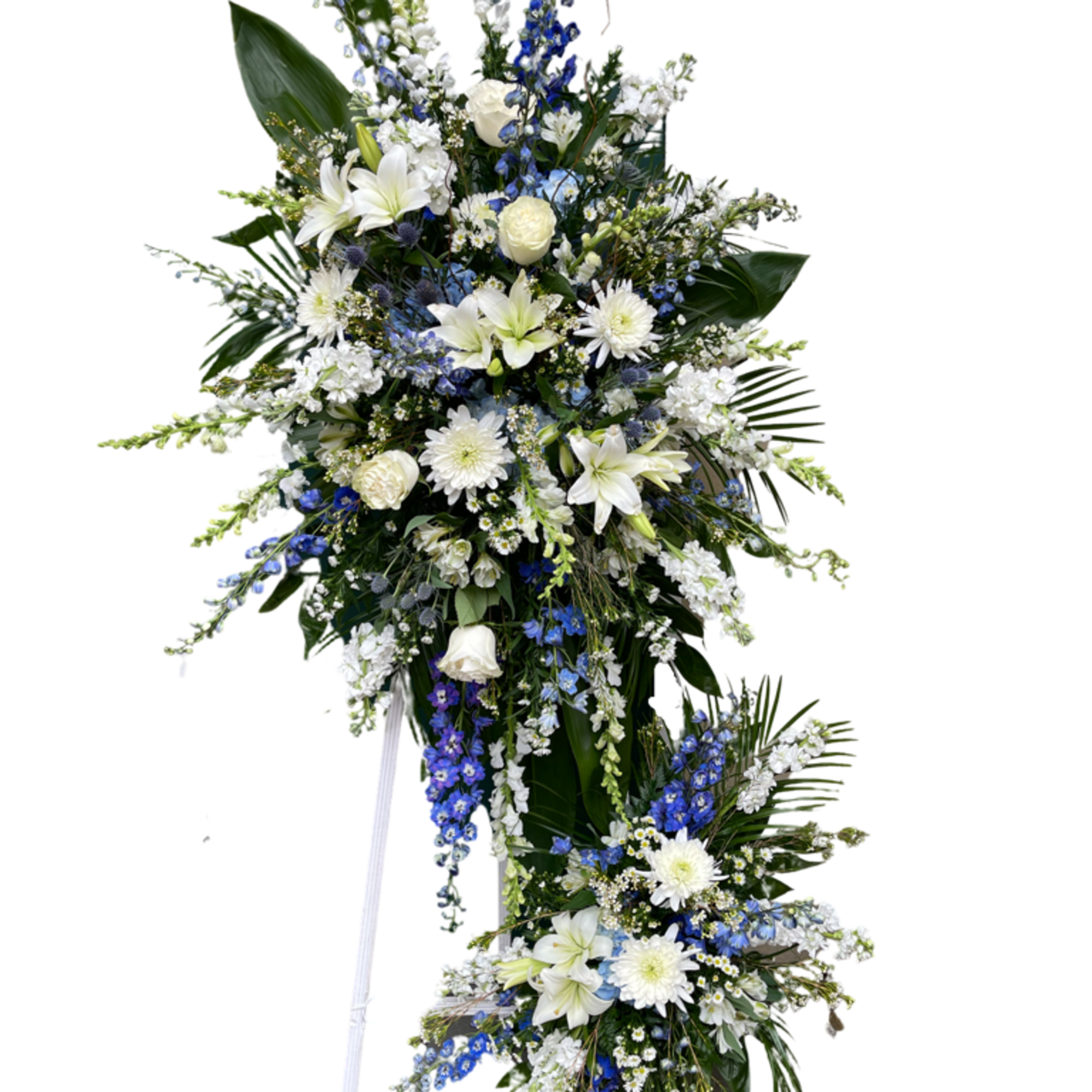Tall white and blue funeral spray on a stand
